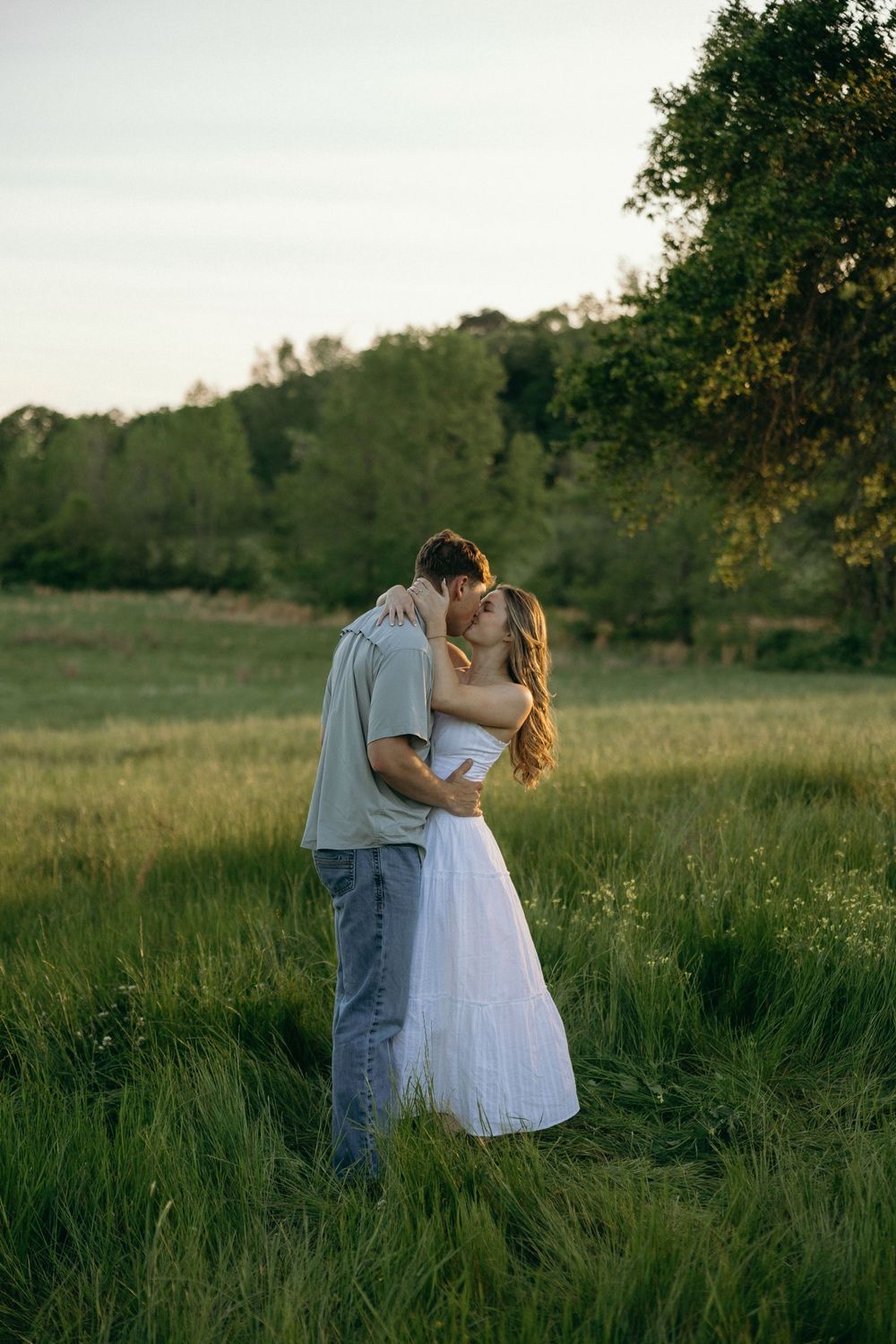 Couple sharing a romantic kiss at a farm during their engagement photos.