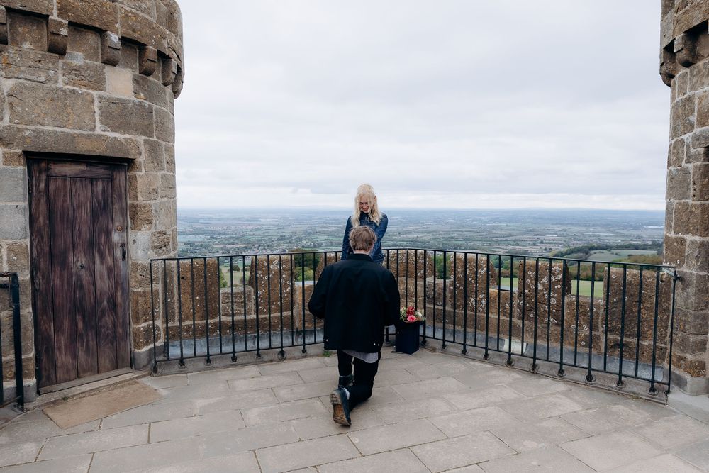 Couple getting engaged at Broadway Tower.