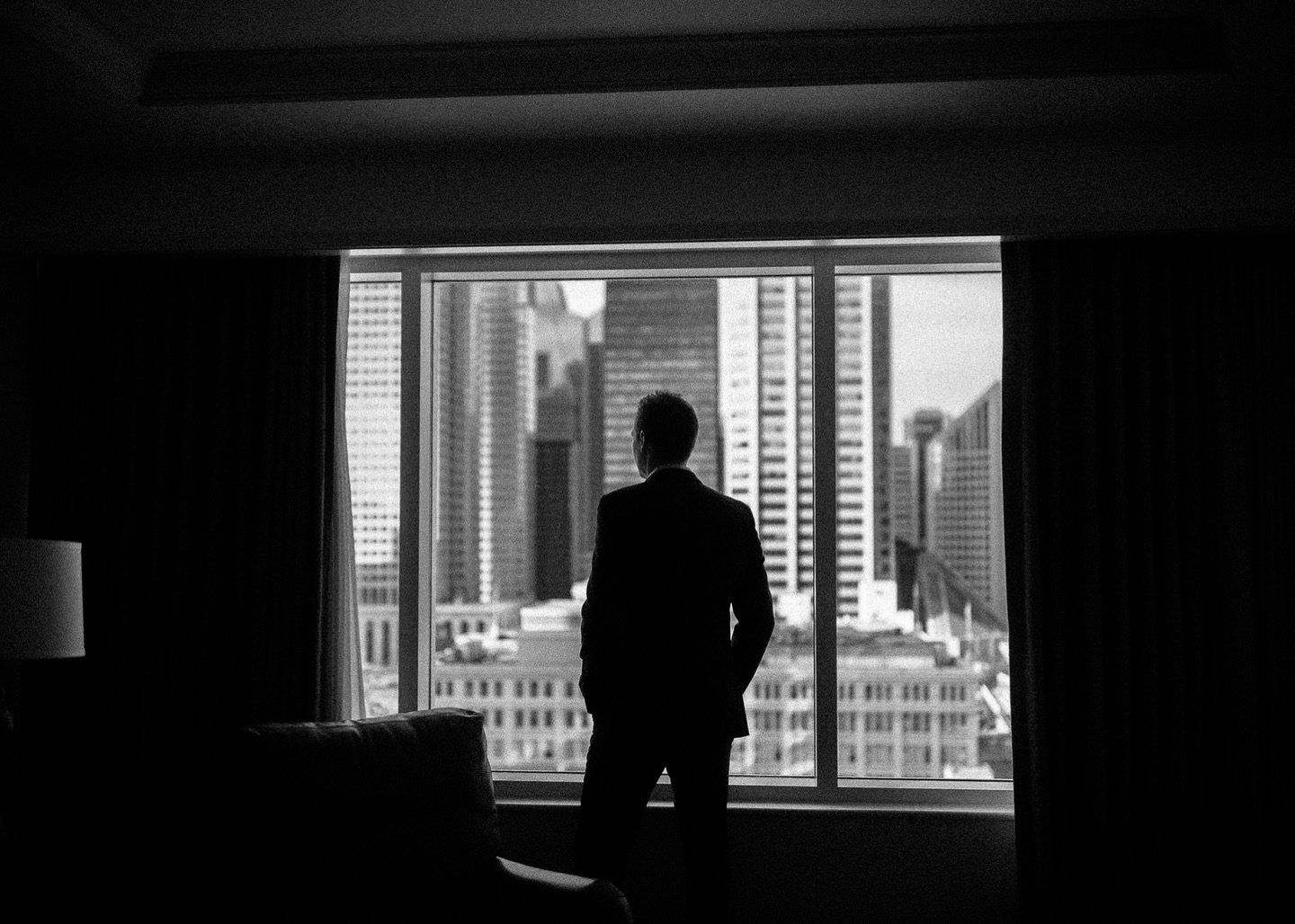 Groom silhouette at a downtown Calgary window before his Teatro wedding