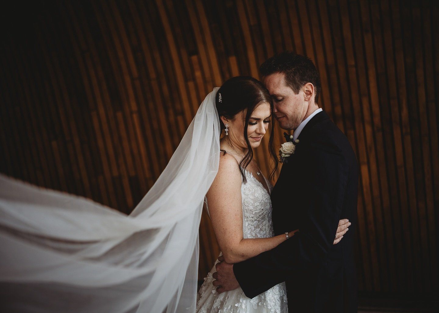 Bride's veil in the wind as Taylor embraces Lindsey, Teatro Calgary wedding