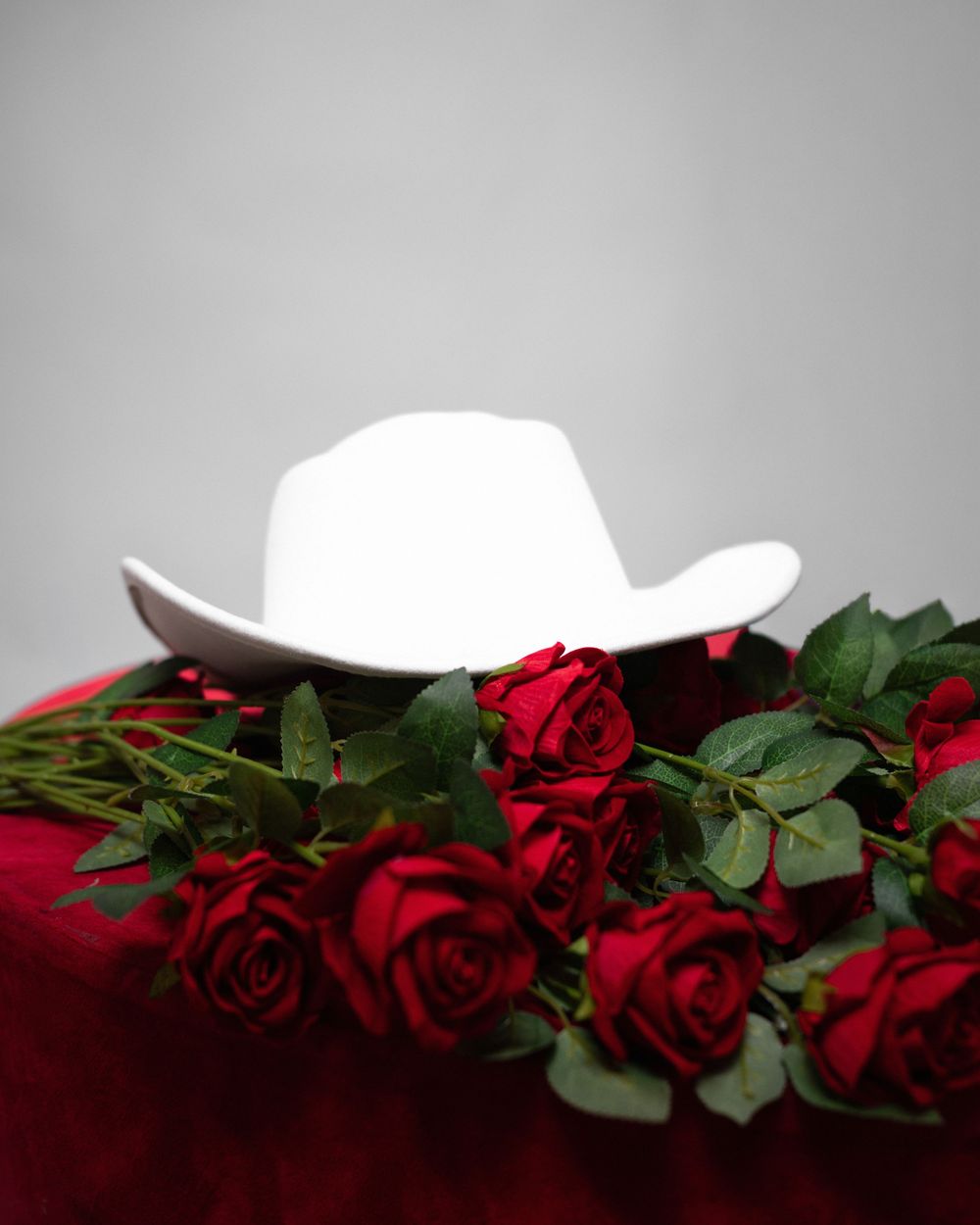 Fotografía de vaquera con rosas y tulipanes sombrero blanco fondo blanco República Dominicana