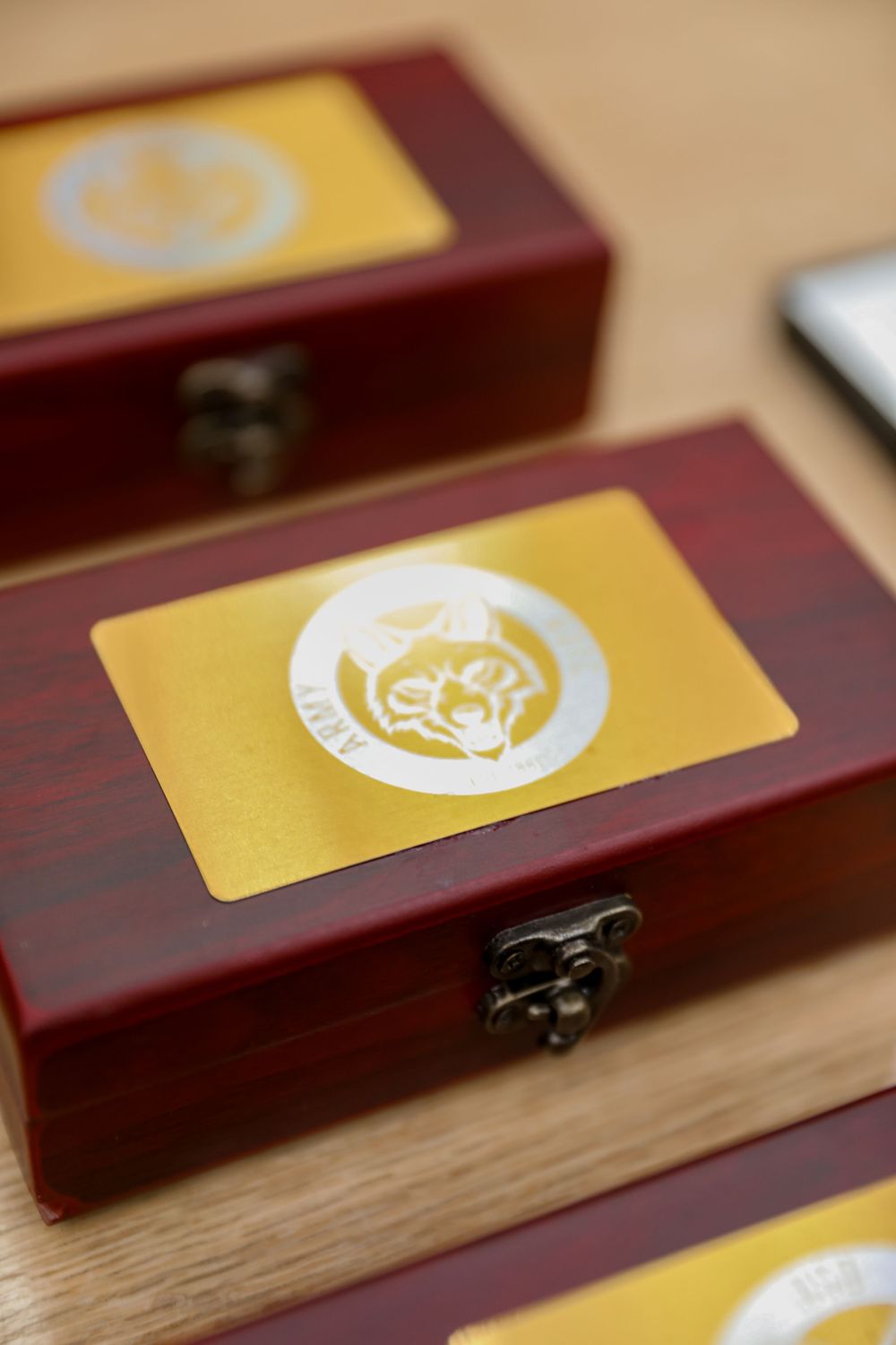 Small wooden keepsake boxes with gold fox logo cards on top, displayed on a wooden surface.
