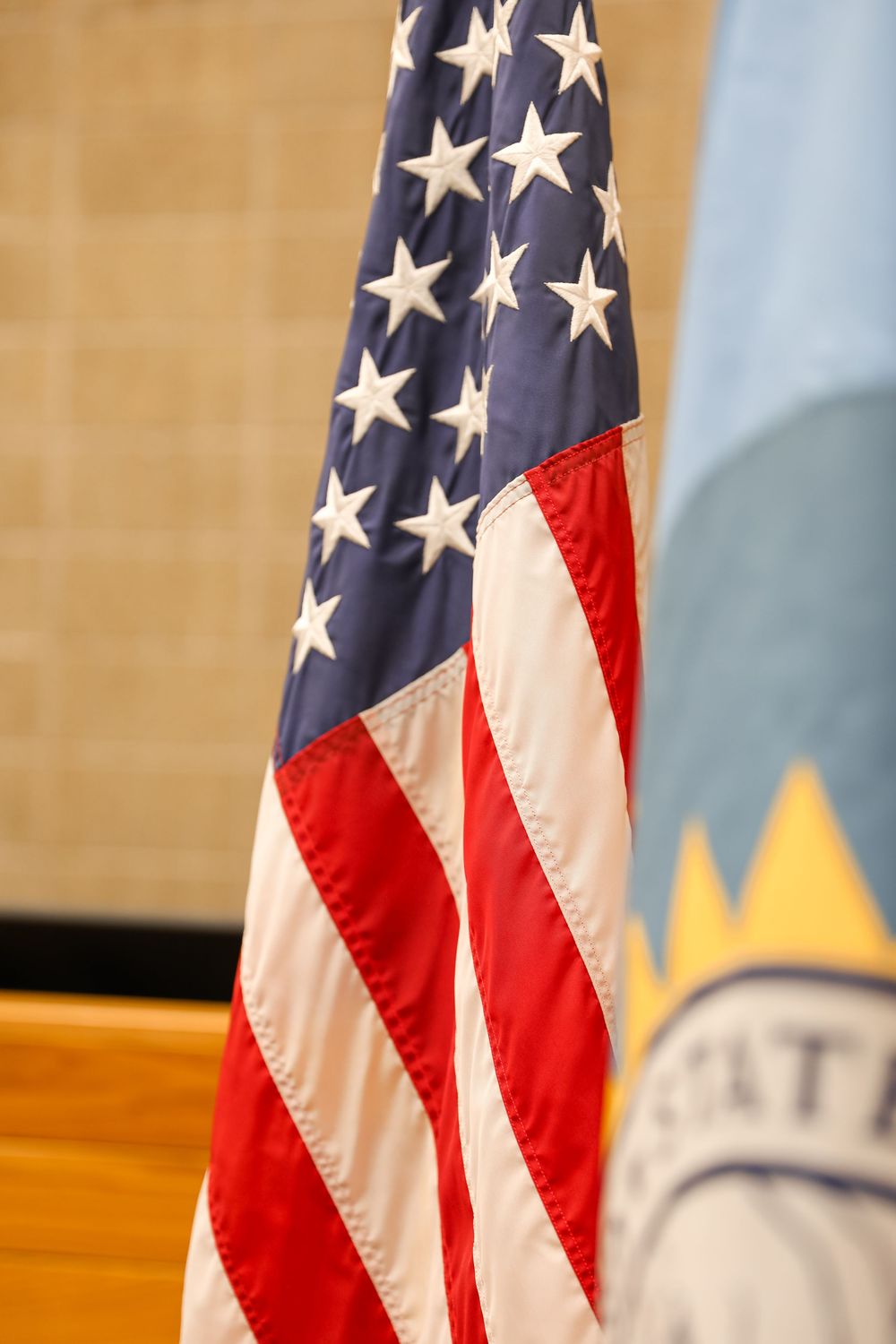 American flag displayed alongside a state flag at an official government ceremony or event.