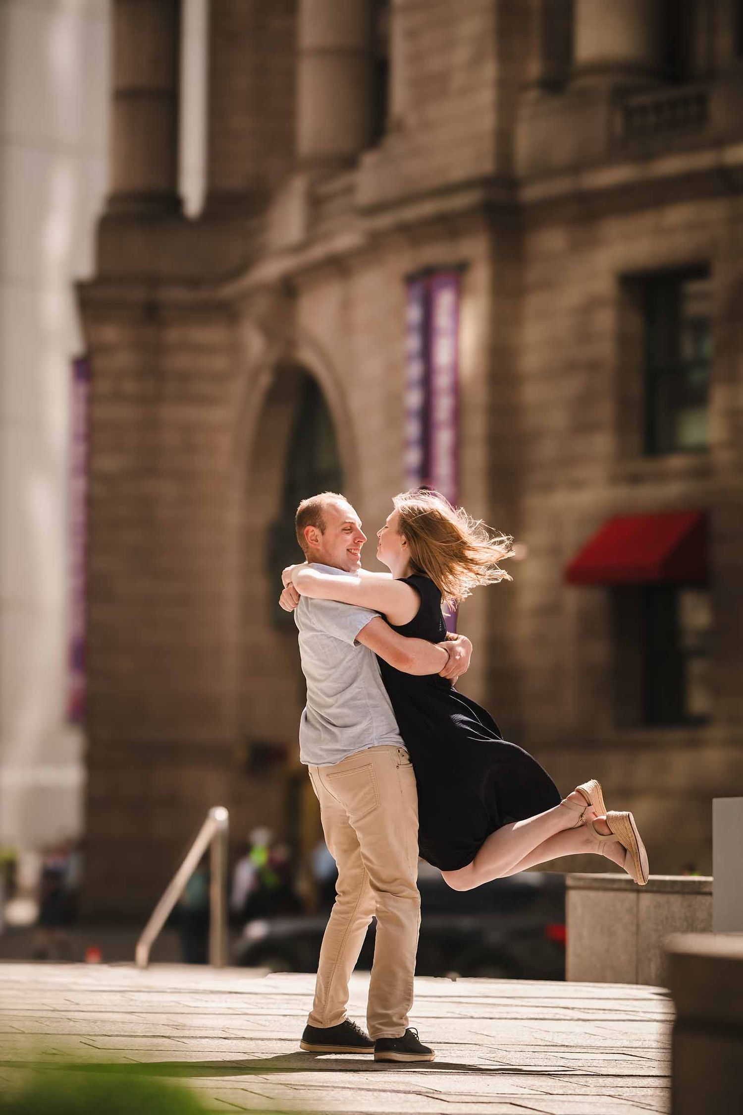 Groom lifting his fiancée and spinning her near South Station in Boston