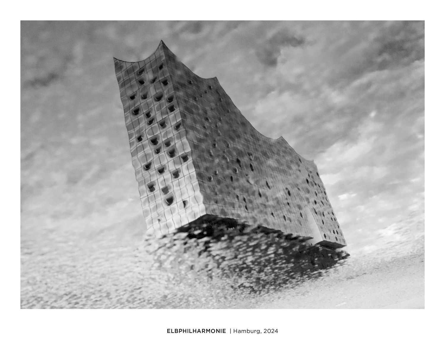 Black and white reflection of Elbphilharmonie Hamburg in a puddle, 2024.