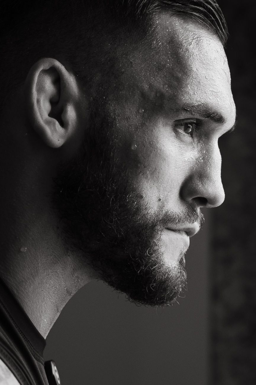 Black and white profile portrait of a bearded man with a serious expression, dramatic lighting.