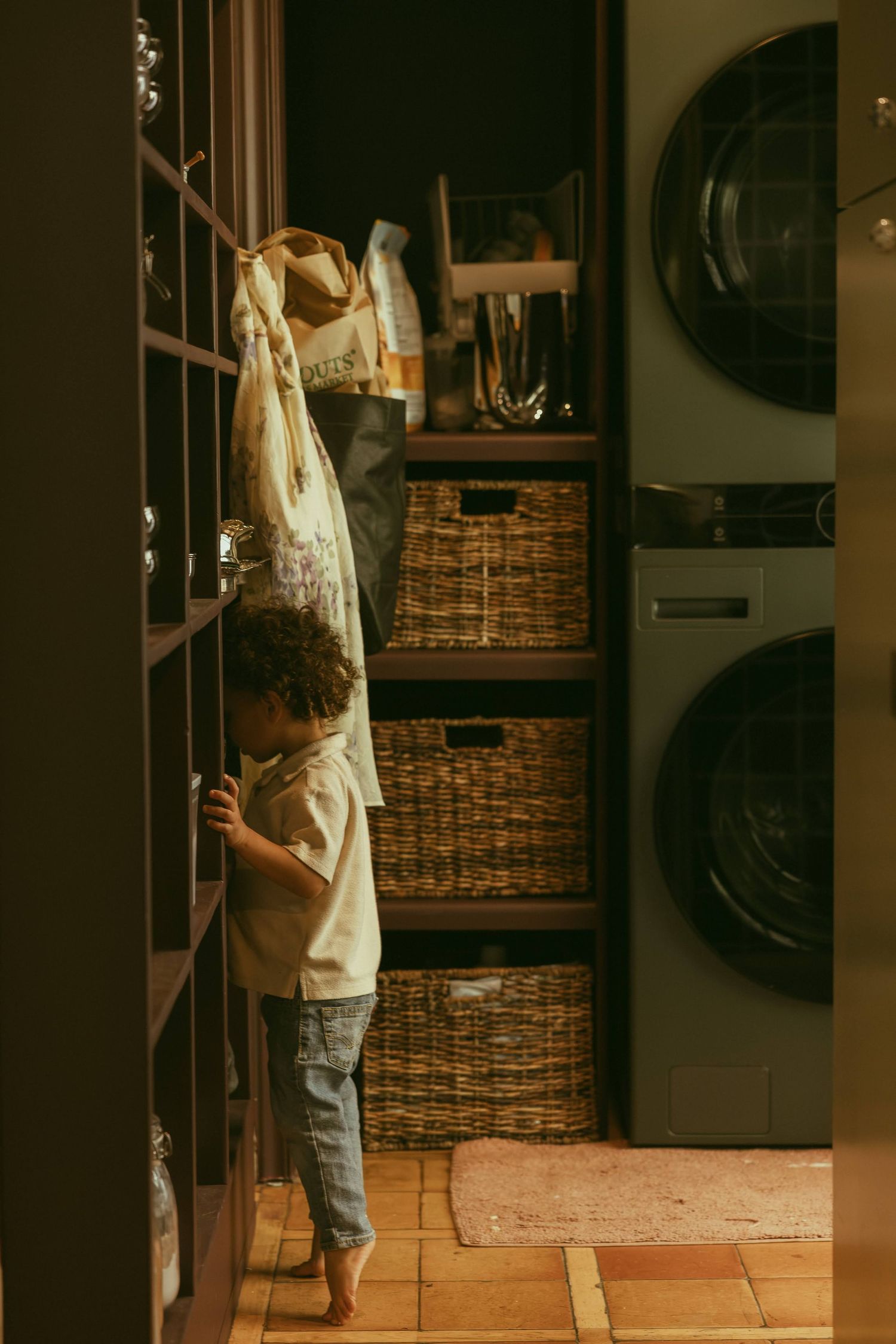 Camera shy curly haired toddler during an in-home family photo session.
