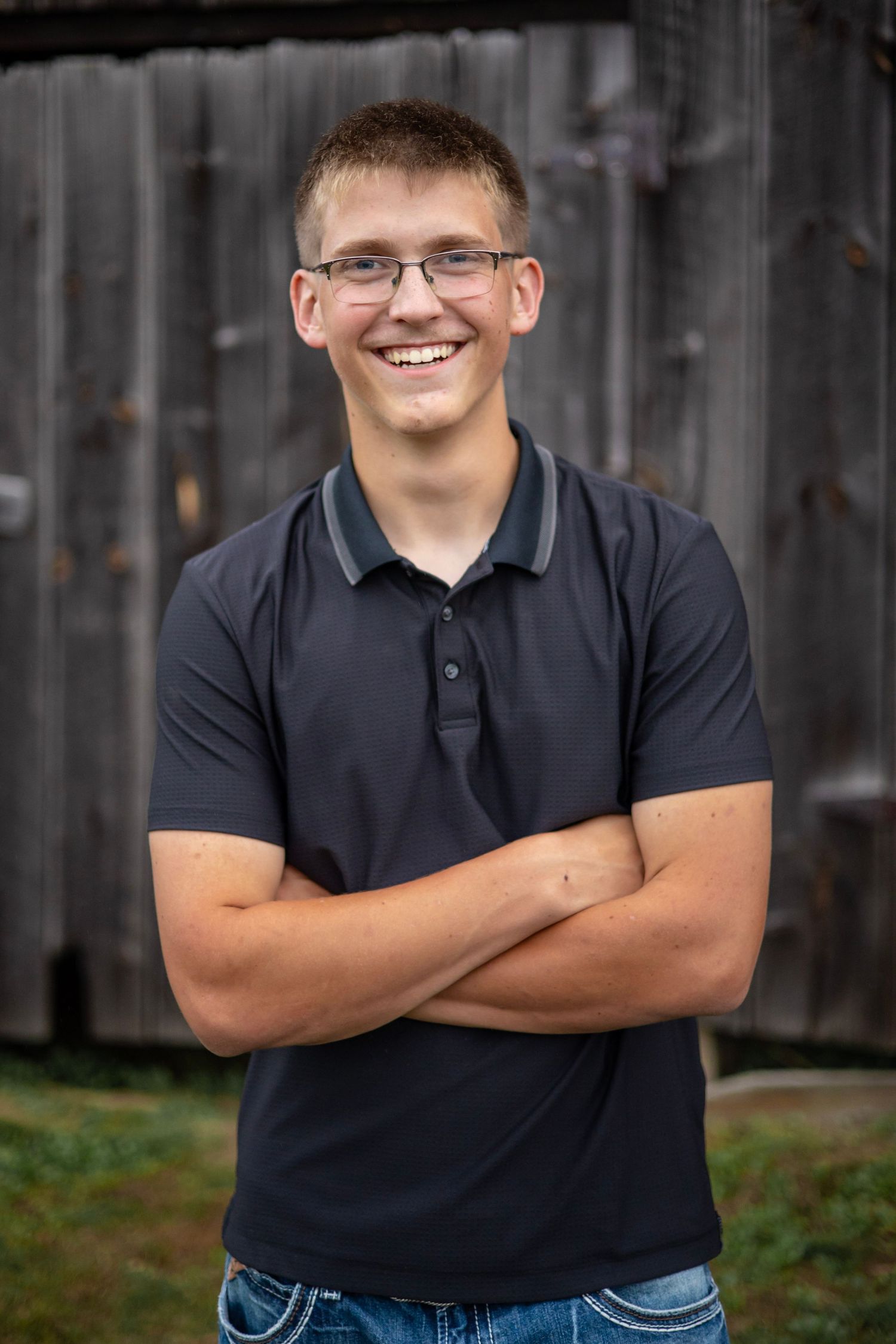 High school senior posing next to a barn in Western Massachusetts