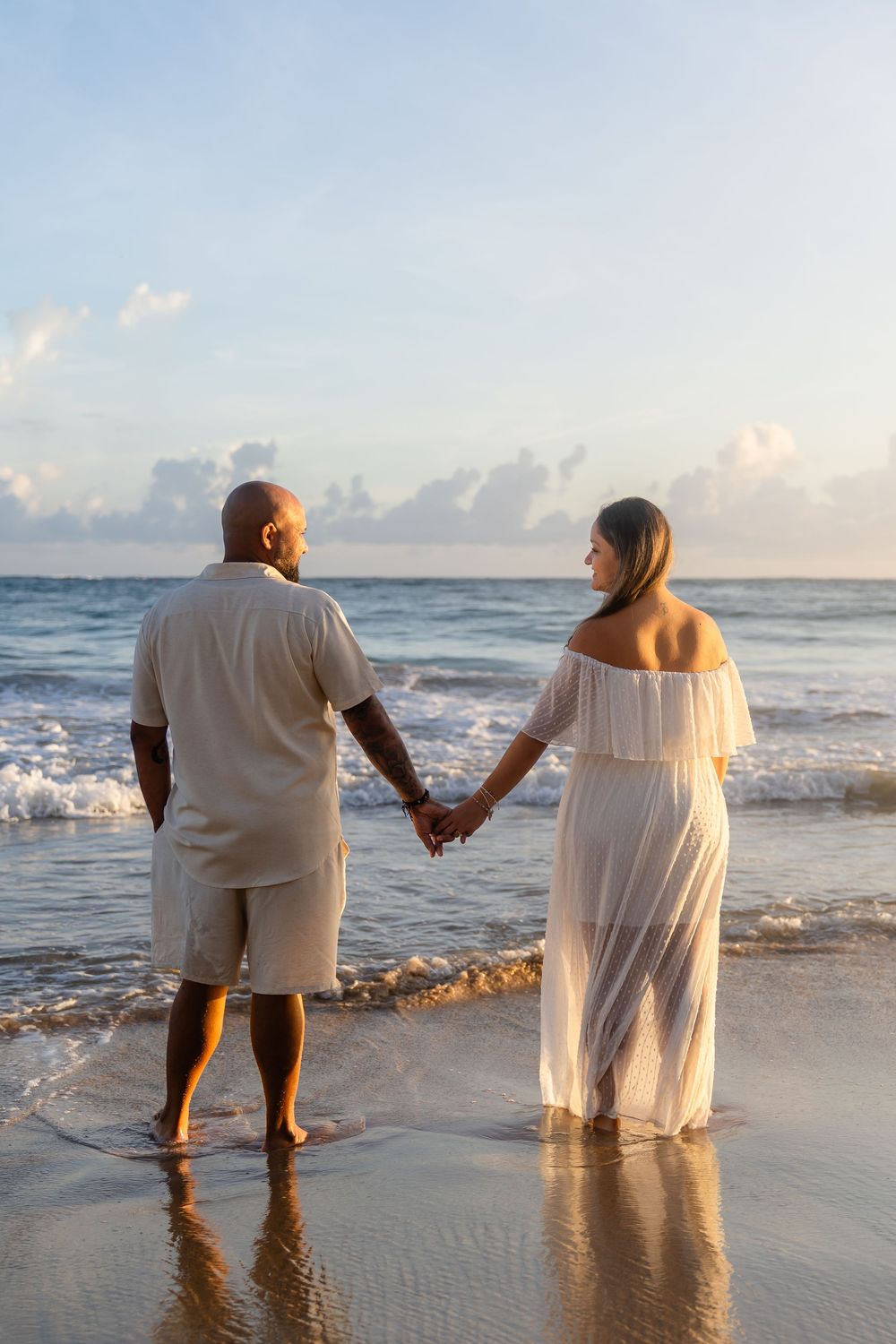 Romantic beach engagement portrait in San Juan with ocean waves at sunrise.