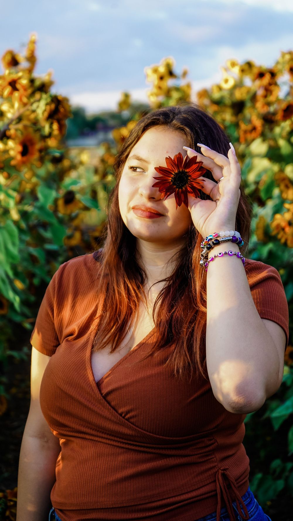 A sunset photoshoot in a field of blooming sunflowers during golden hour.