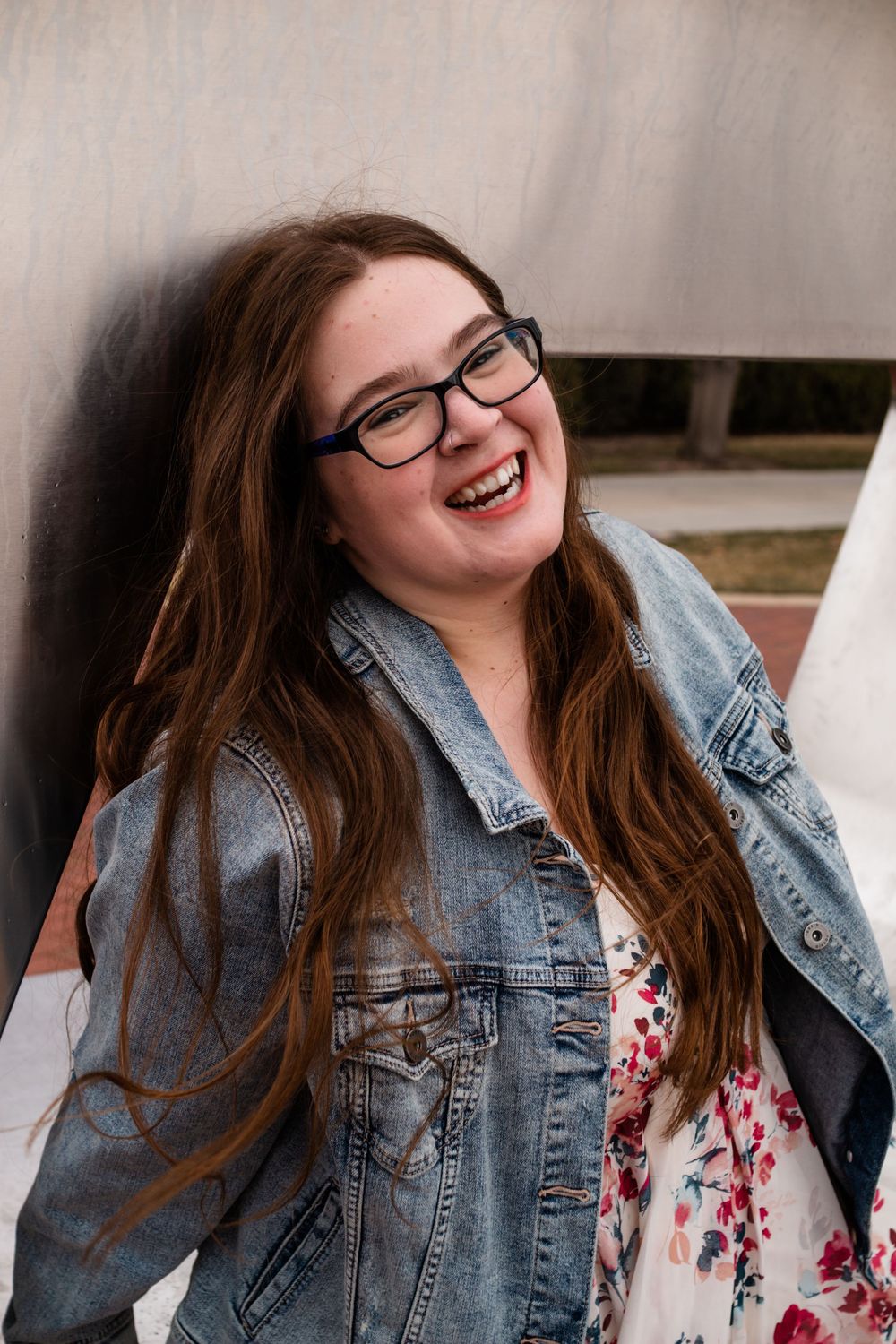 A series of candid portrait shots against a neutral wall wearing denim and floral prints.