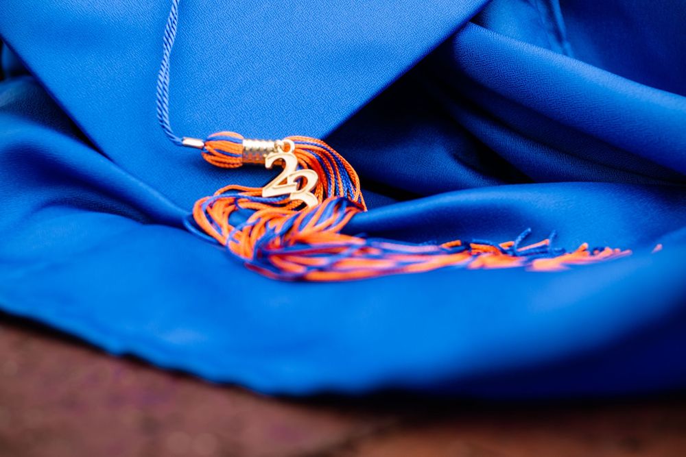 Close-up detail shots of blue graduation tassel with orange and white cords.