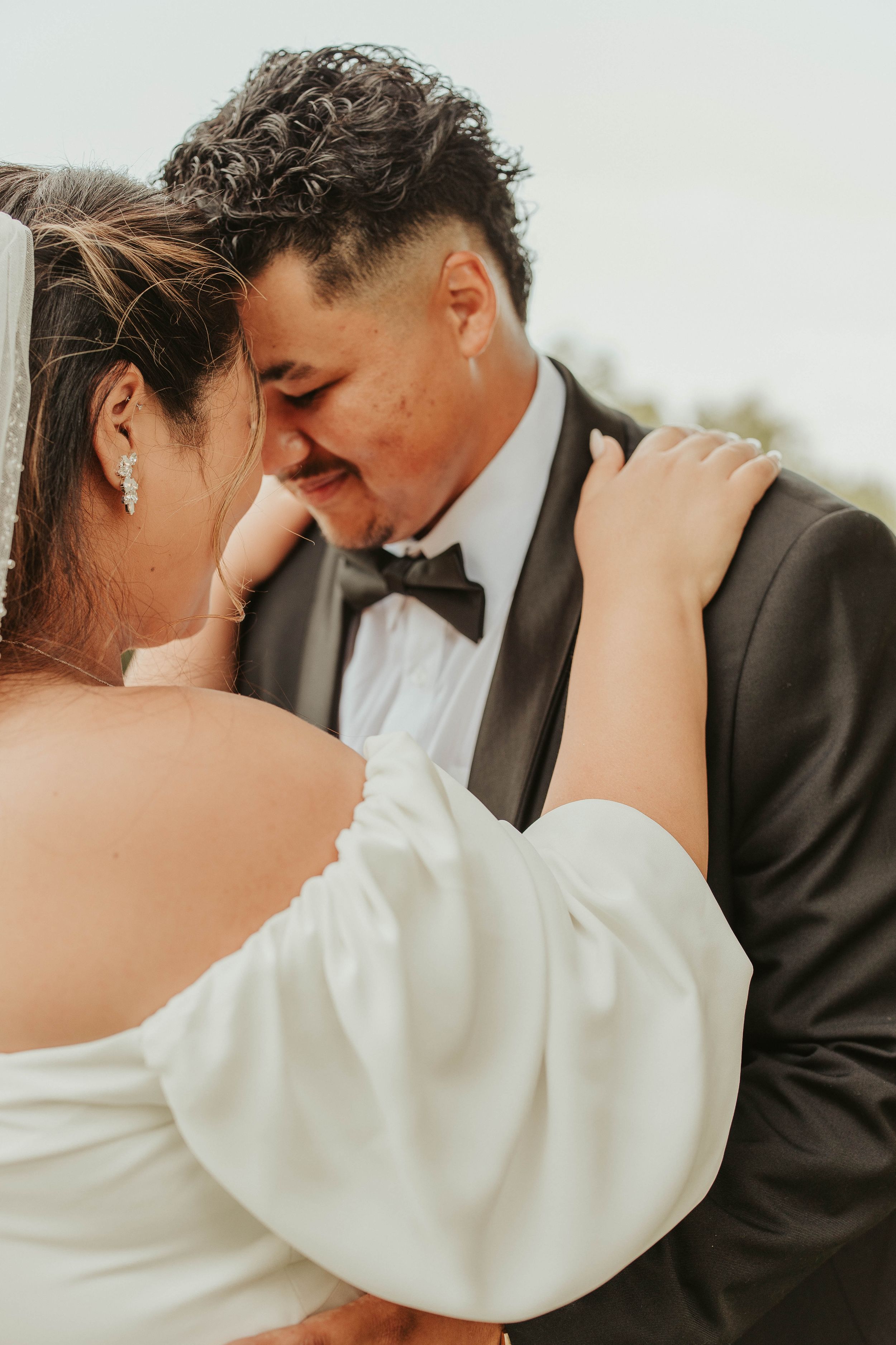 Close-up of newlyweds sharing an intimate moment in formal wedding attire.