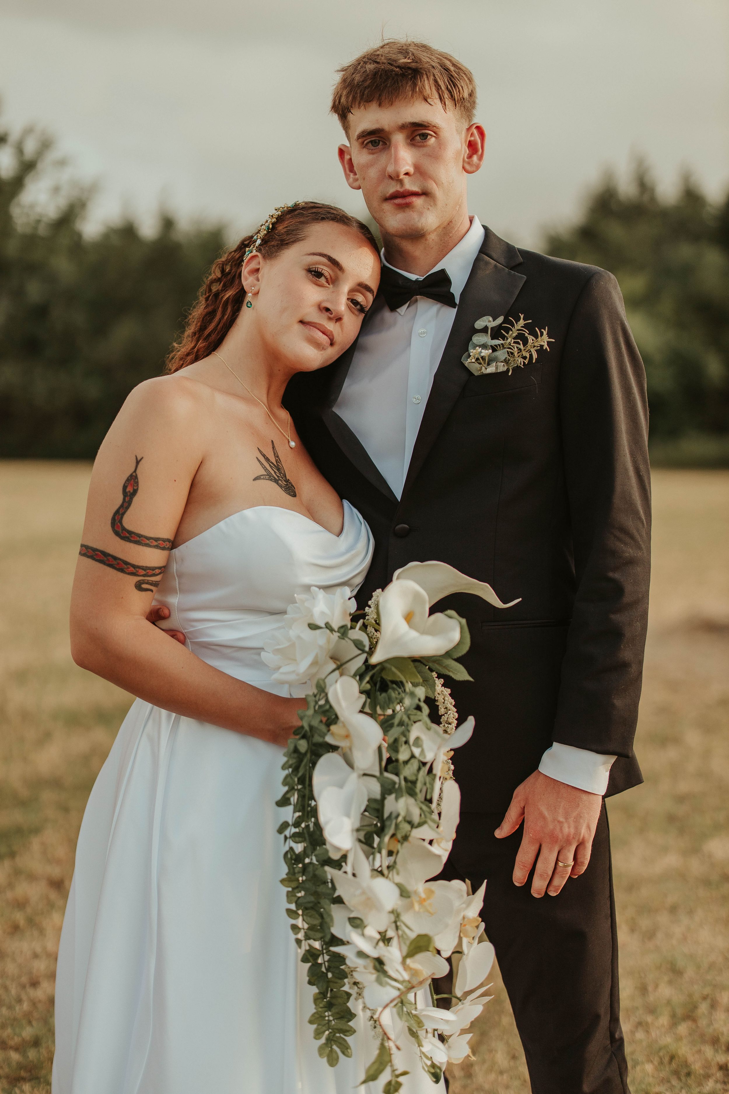 Elegant wedding portrait featuring white lily bouquet and classic bridal attire.
