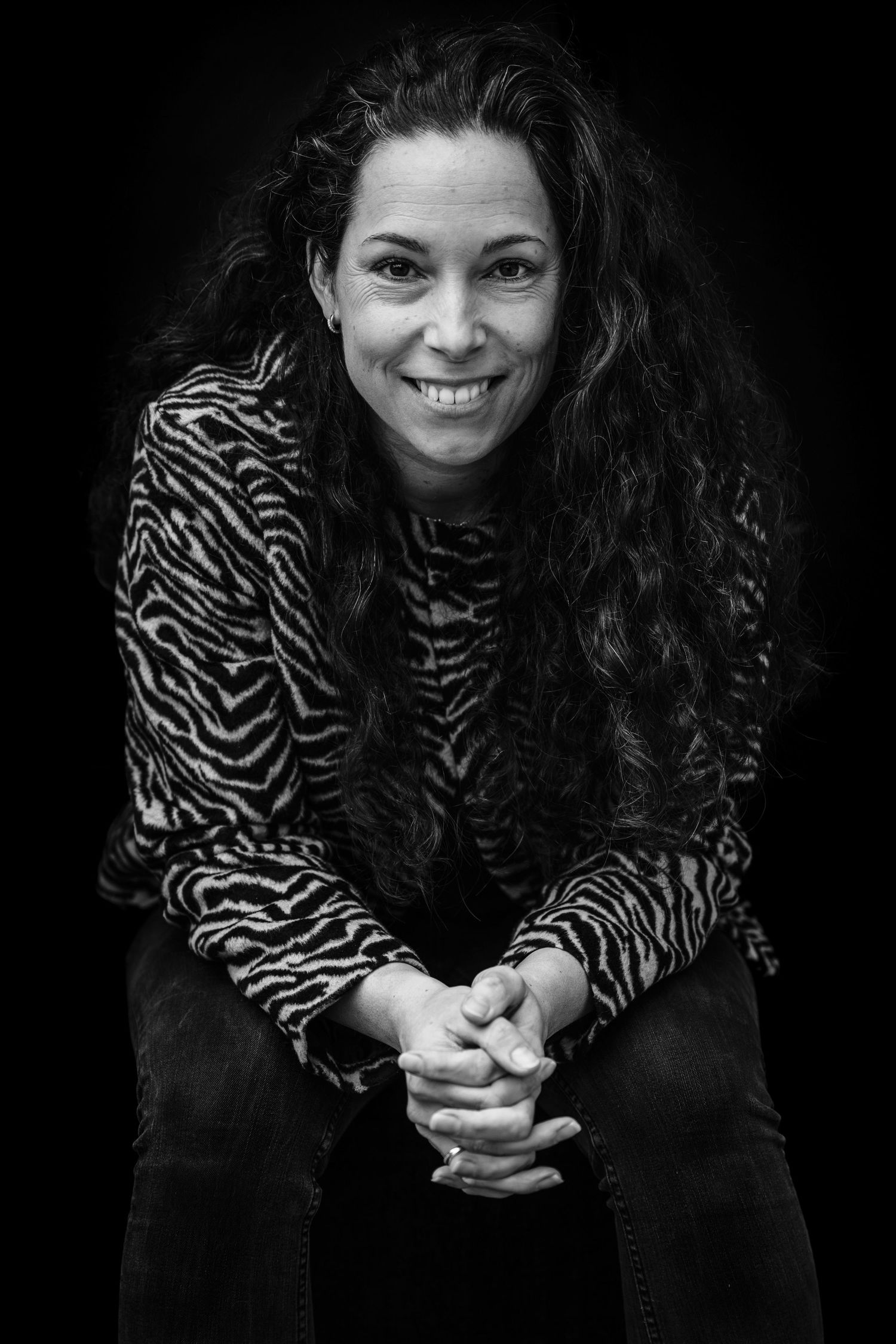 Black and white portrait series showing a person in a zebra print top against a dark background.