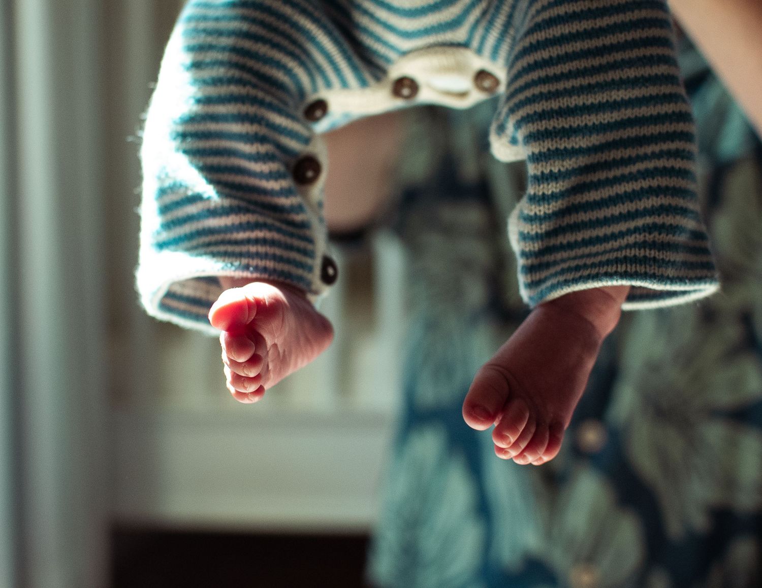 Newborn’s feet in the air during in home newborn session in Minnesota.