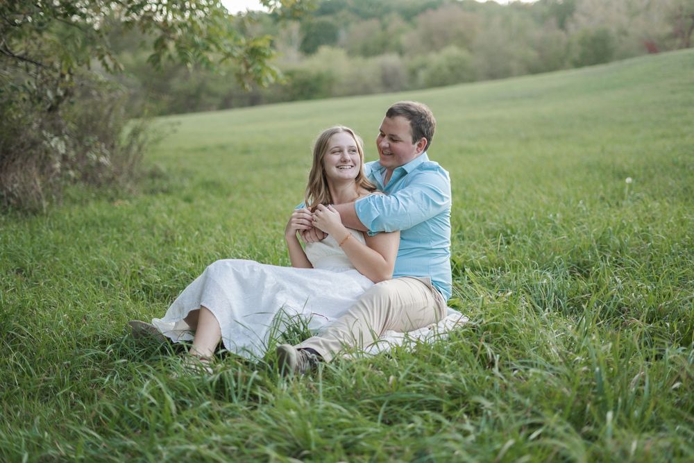 A couple sitting in a field.