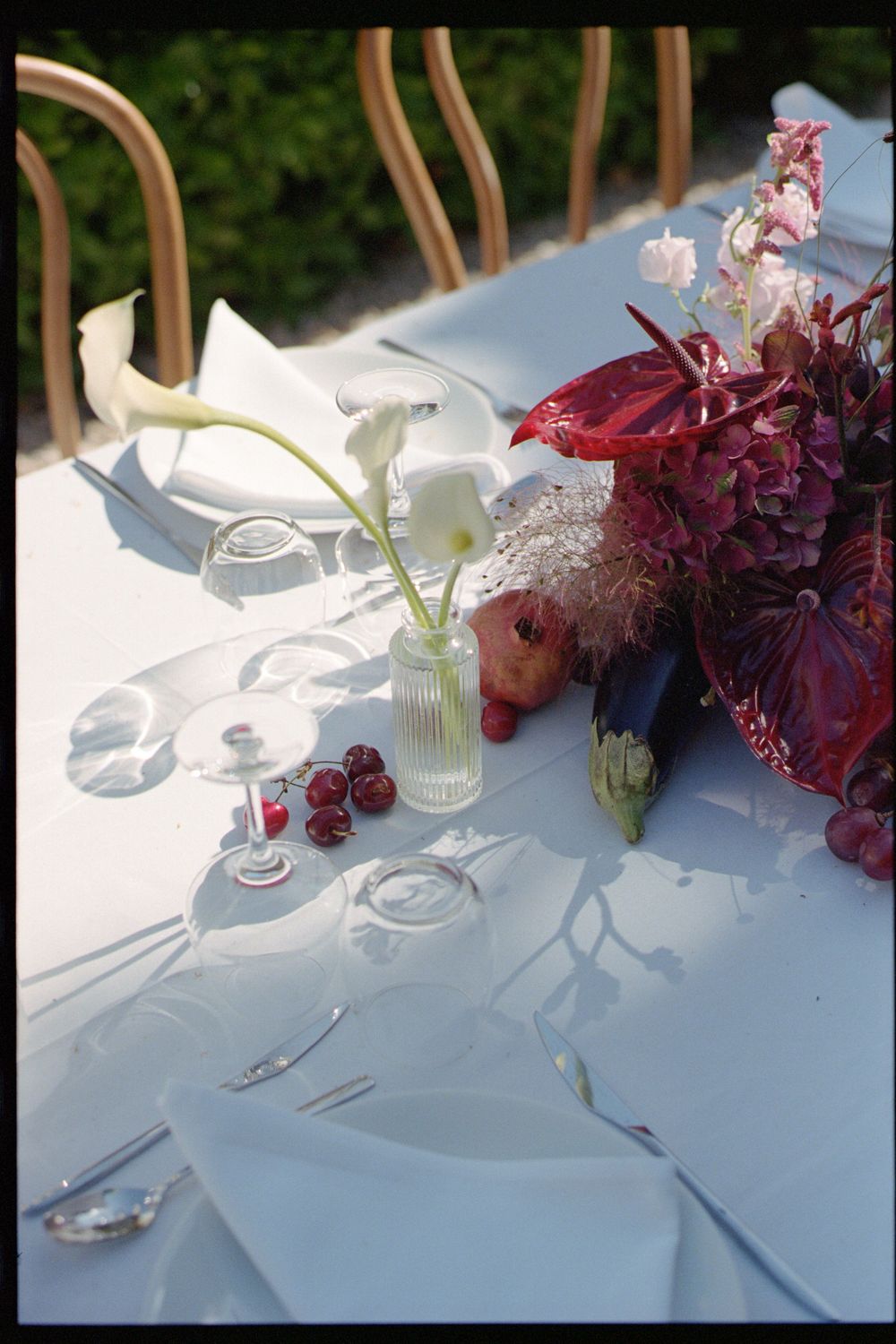 Elegant table settings with white linens and deep burgundy floral arrangements create a sophisticated dining atmosphere.
