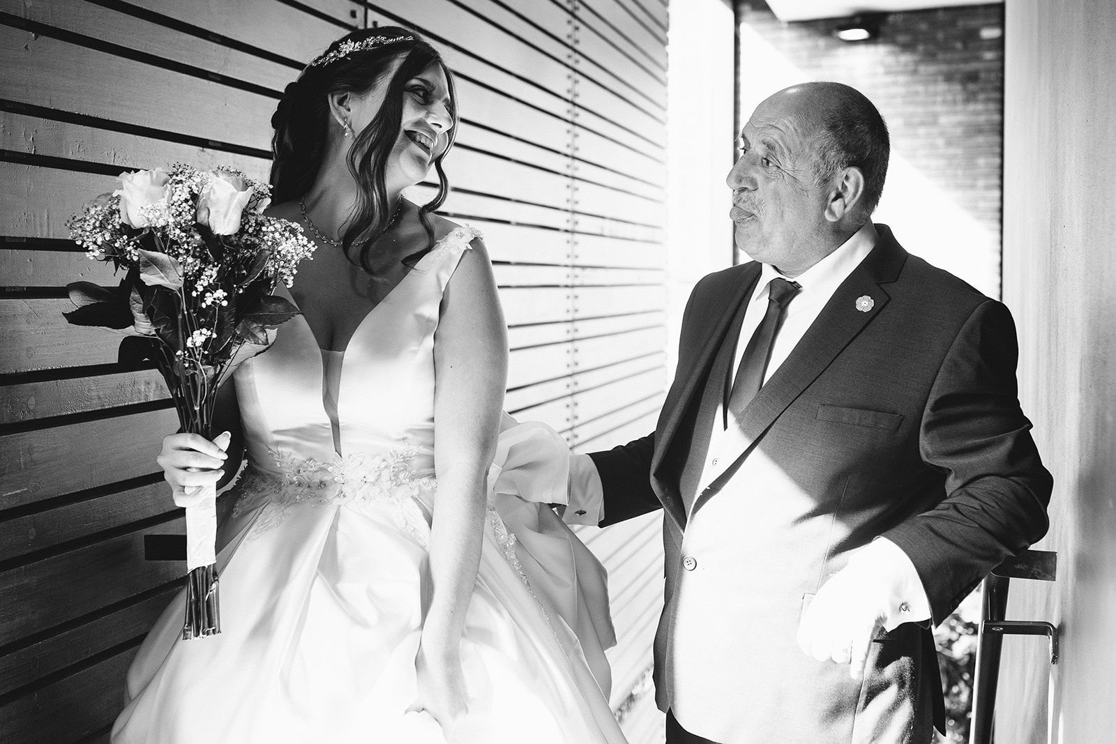 Intimate black and white wedding portraits captured along a geometric wall.