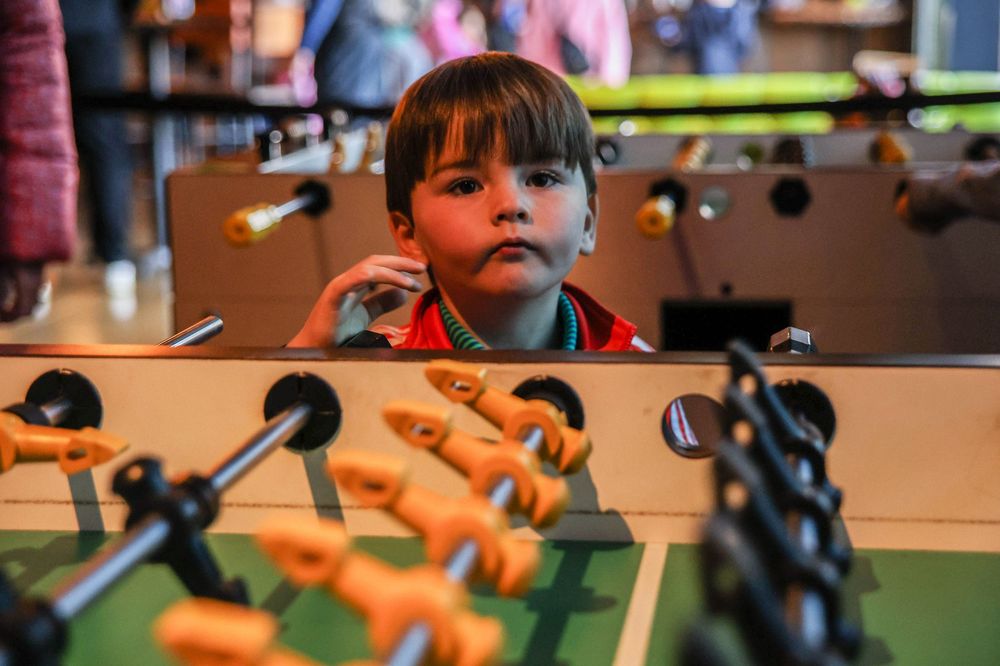 A little boy near a foosball table.
