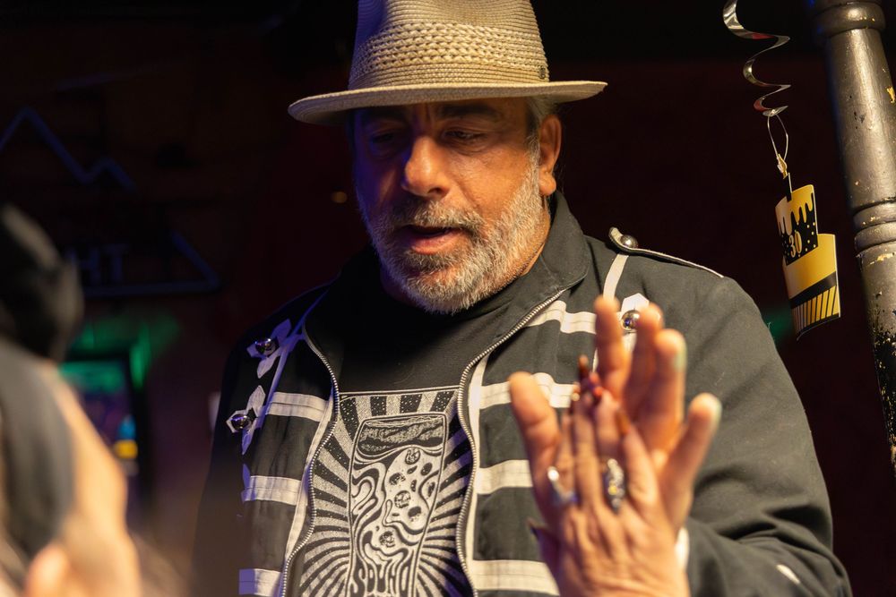 A man in a jacket and a hat giving a high five.
