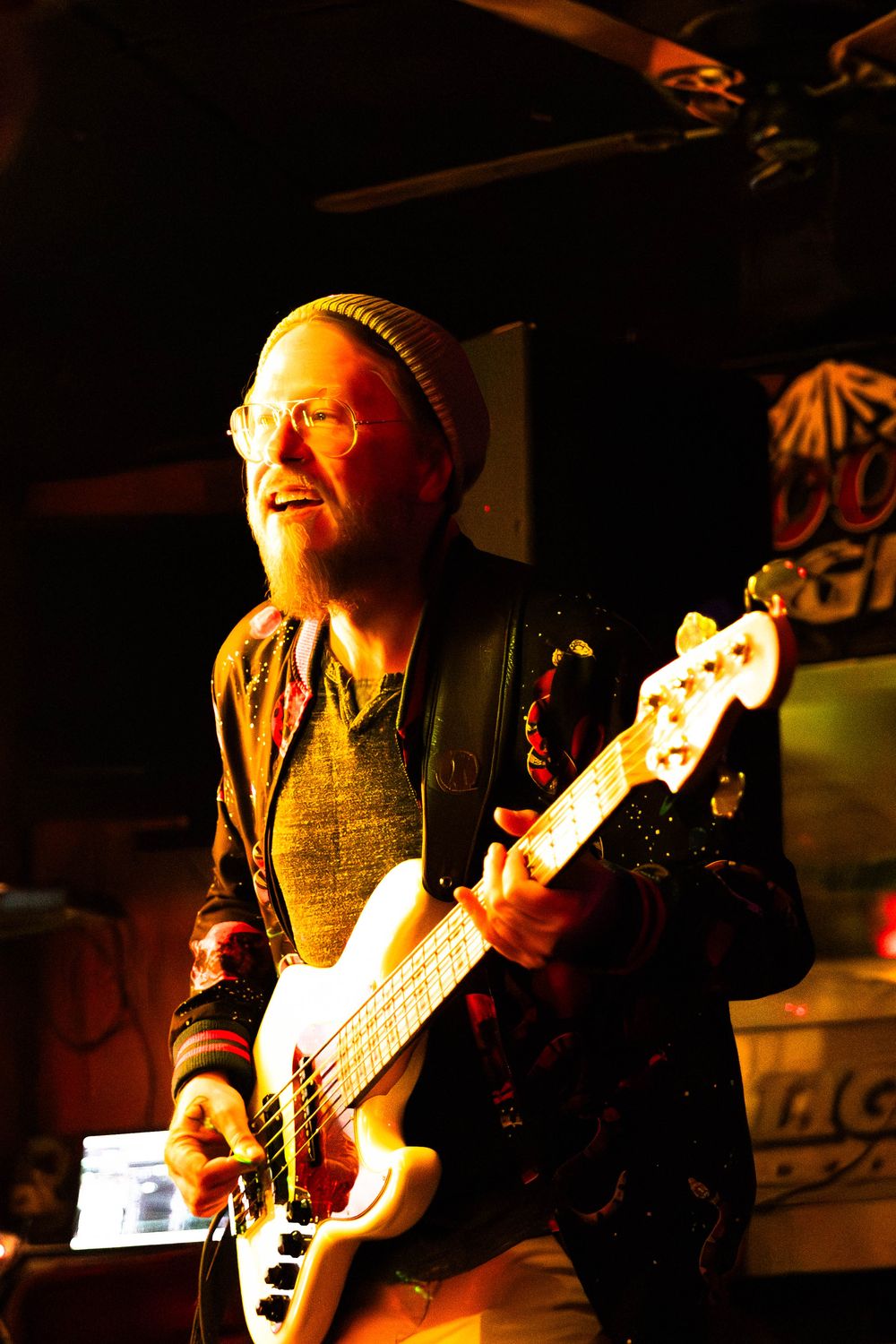 A photo of a man playing a bass guitar.