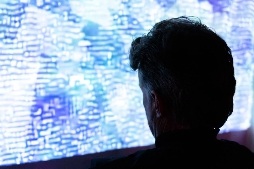 A photo of a man looking at a screen.