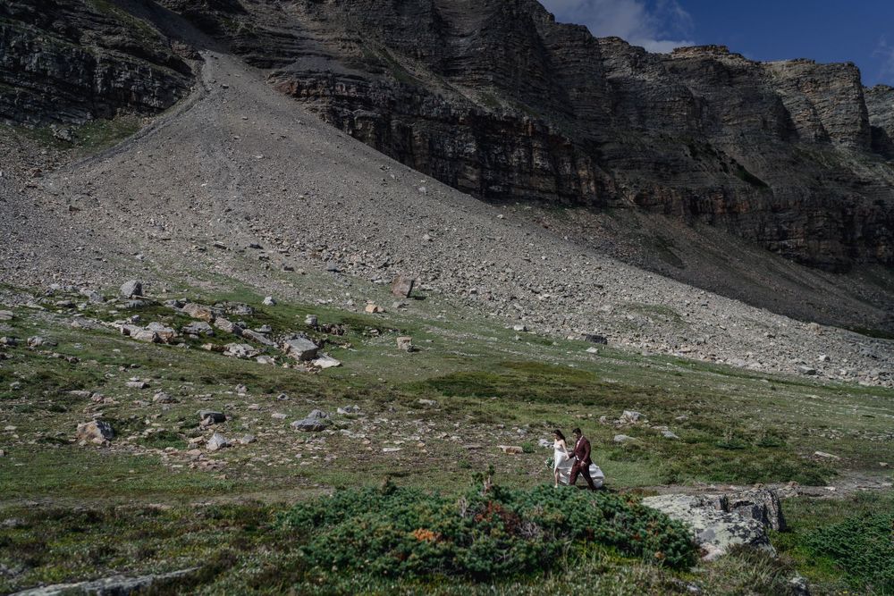 Rocky mountain landscape with hiking trails and scattered vegetation in rugged terrain.