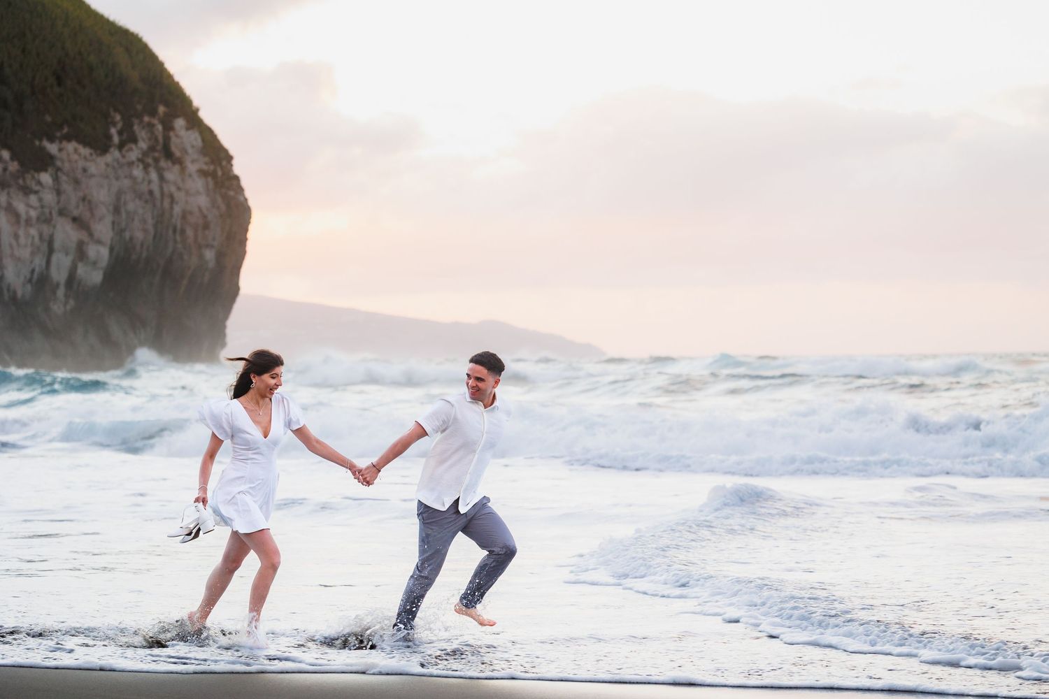 Happy couple laughing by the ocean.