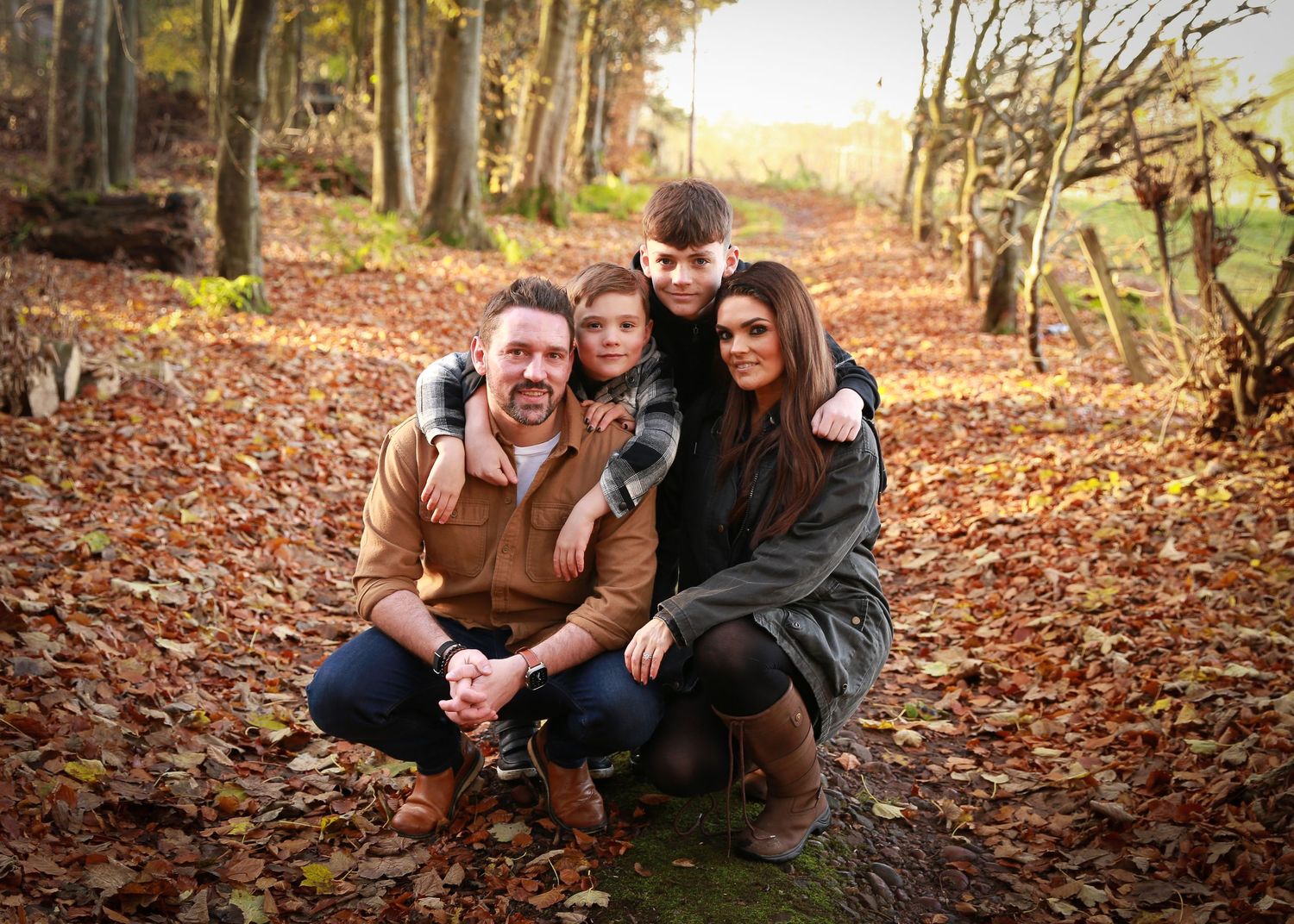 A joyful family enjoying a moment together in the tranquil surroundings of Dunnottar Woods, capturing the beauty of nature and connection