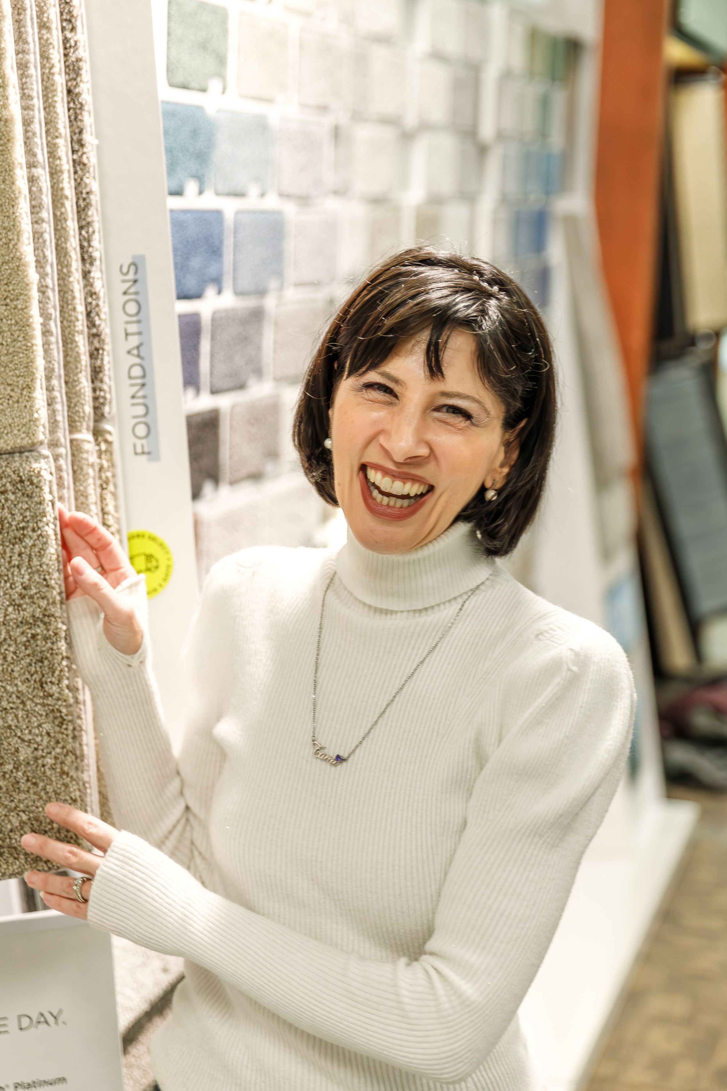 A person in a white turtleneck sweater poses and smiles cheerfully in a series of connected photos.