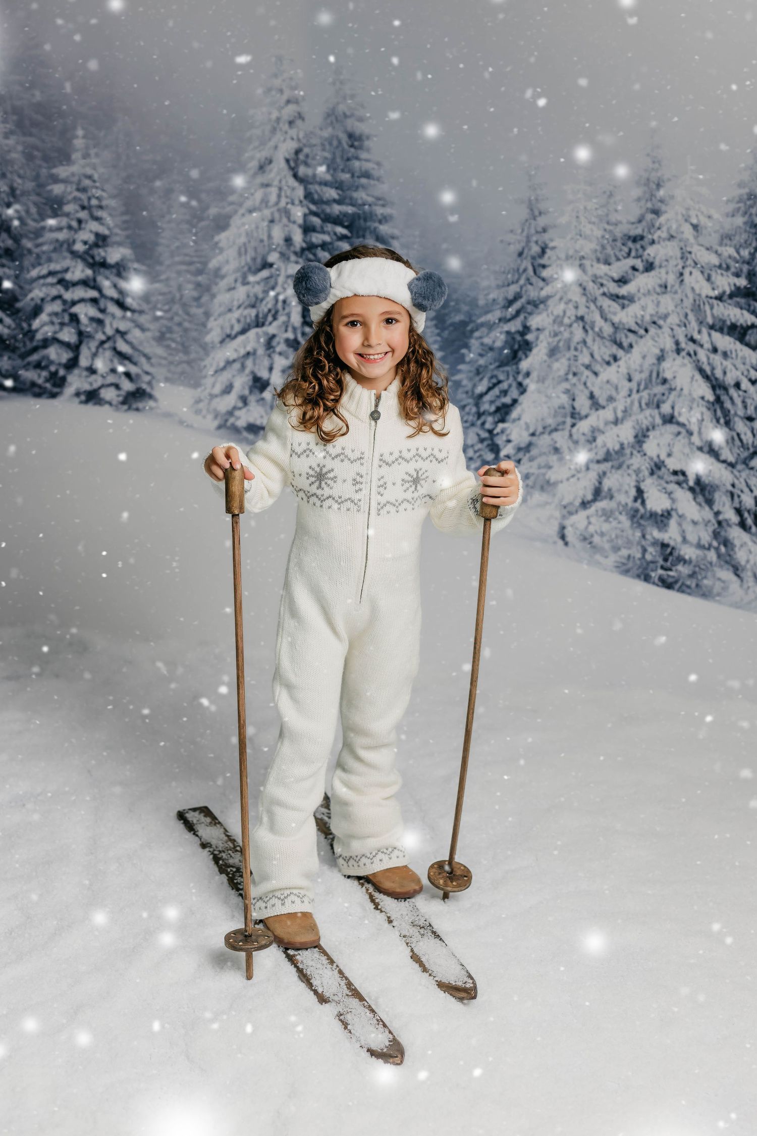 fotografía de una niña con vestimenta de esquiar y unos esquís en la nieve con un fondo de pinos nevados