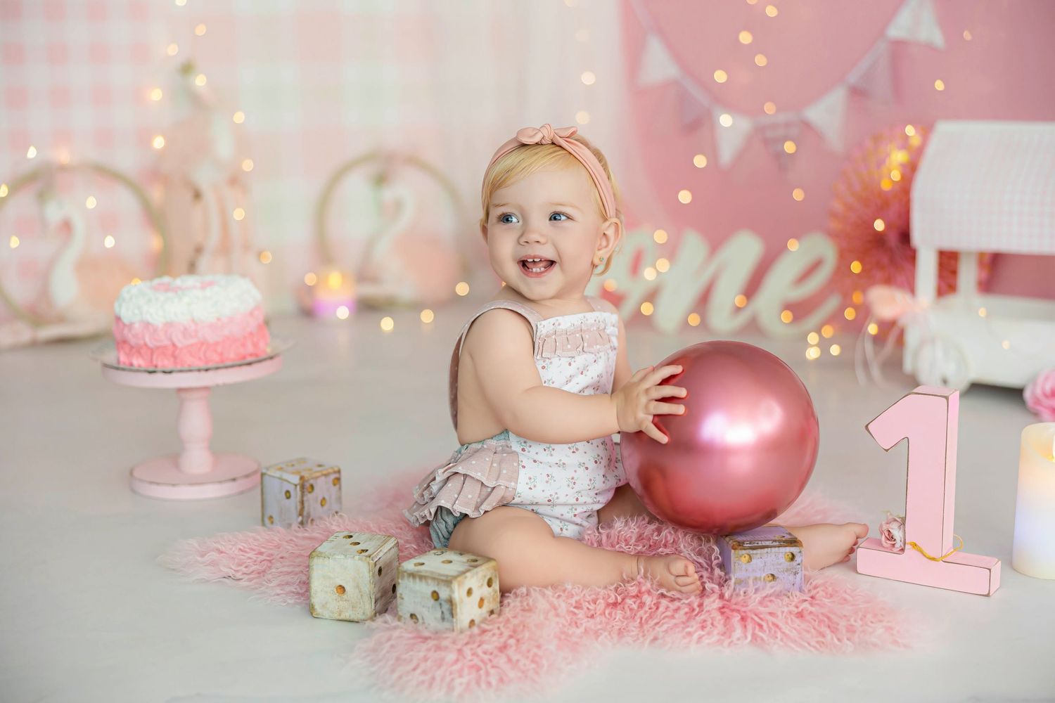 Celebración de primer cumpleaños de una niña con tarta y decoración en tonos rosas