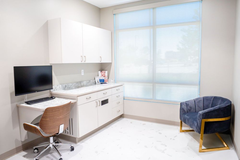 Clean modern medical exam room with desk, computer and blue accent chair. Quad Cities Real Estate Photography