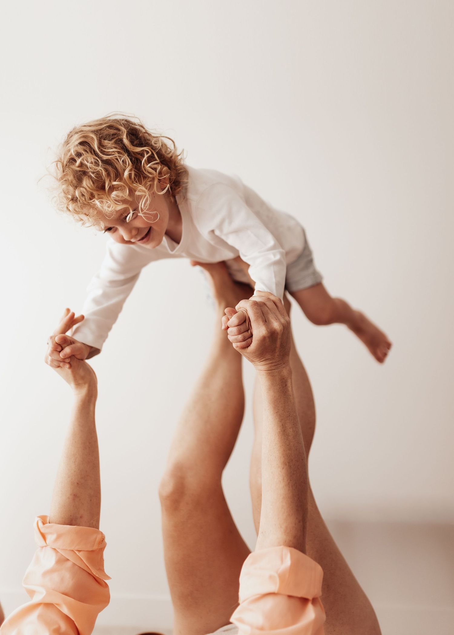 A series of baby feet in white socks shown in different playful positions against a light background.
