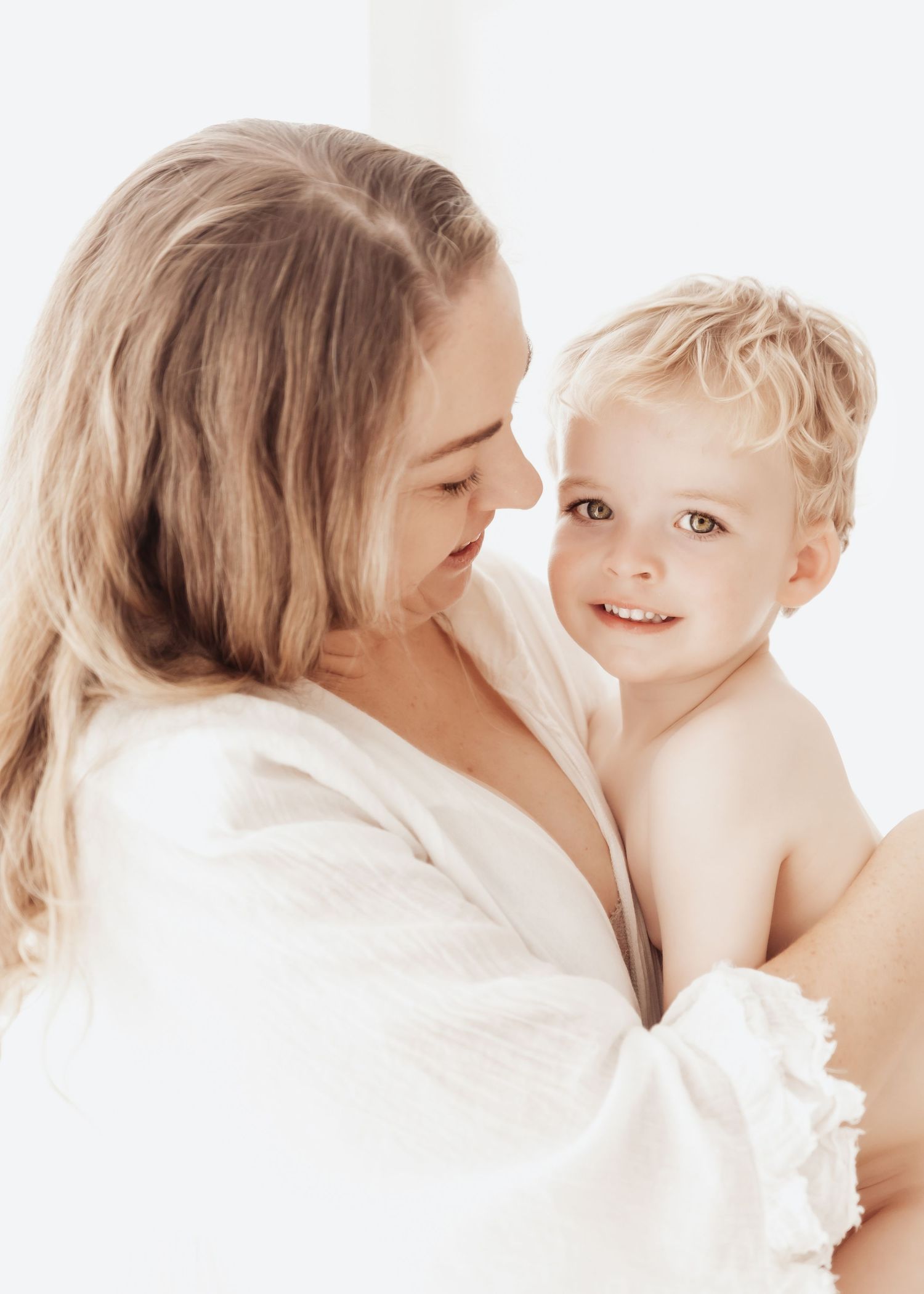 A tender series of intimate moments between a parent and child in white, showing loving interaction and bonding.