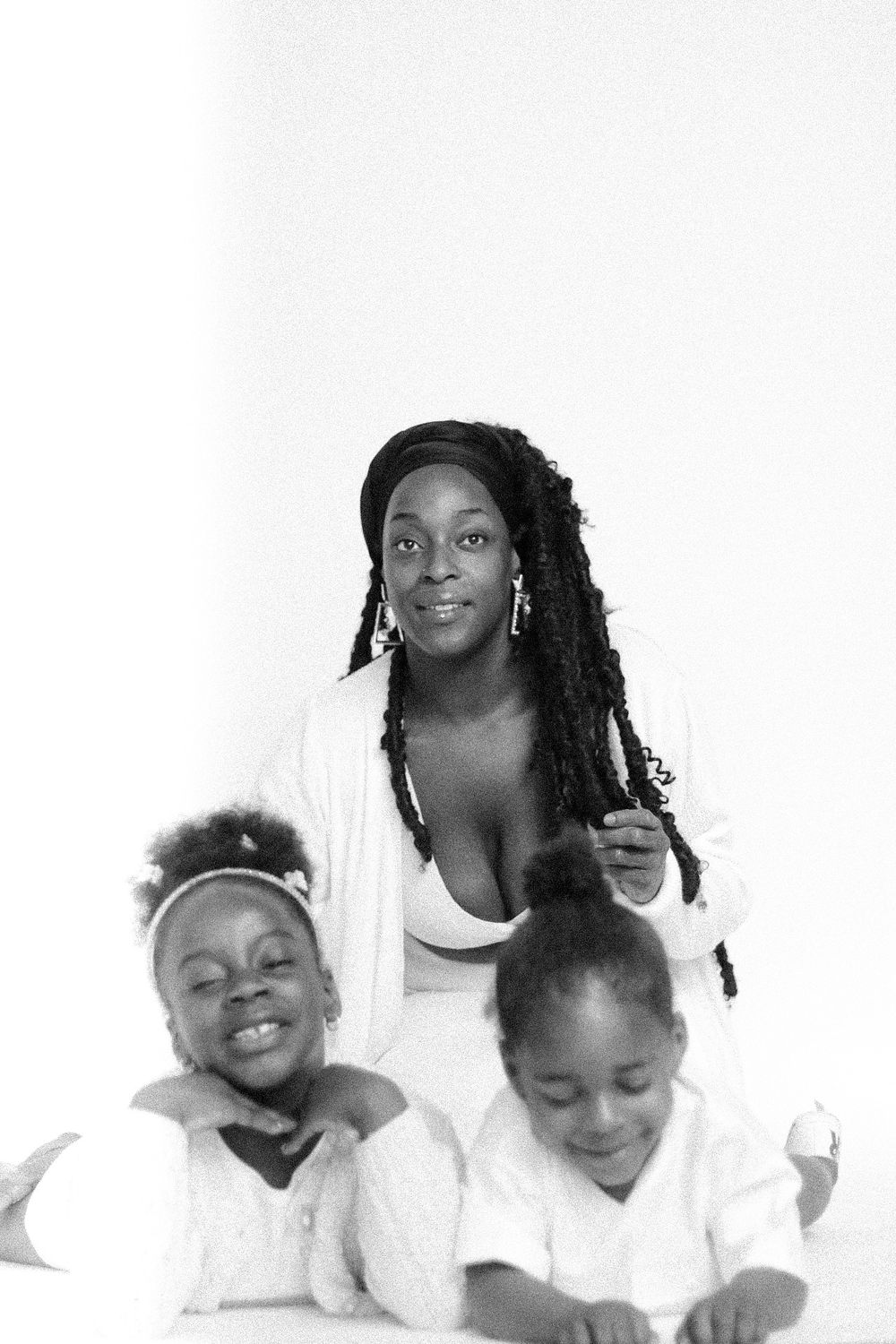 Black and white family portrait with three people in white clothing.