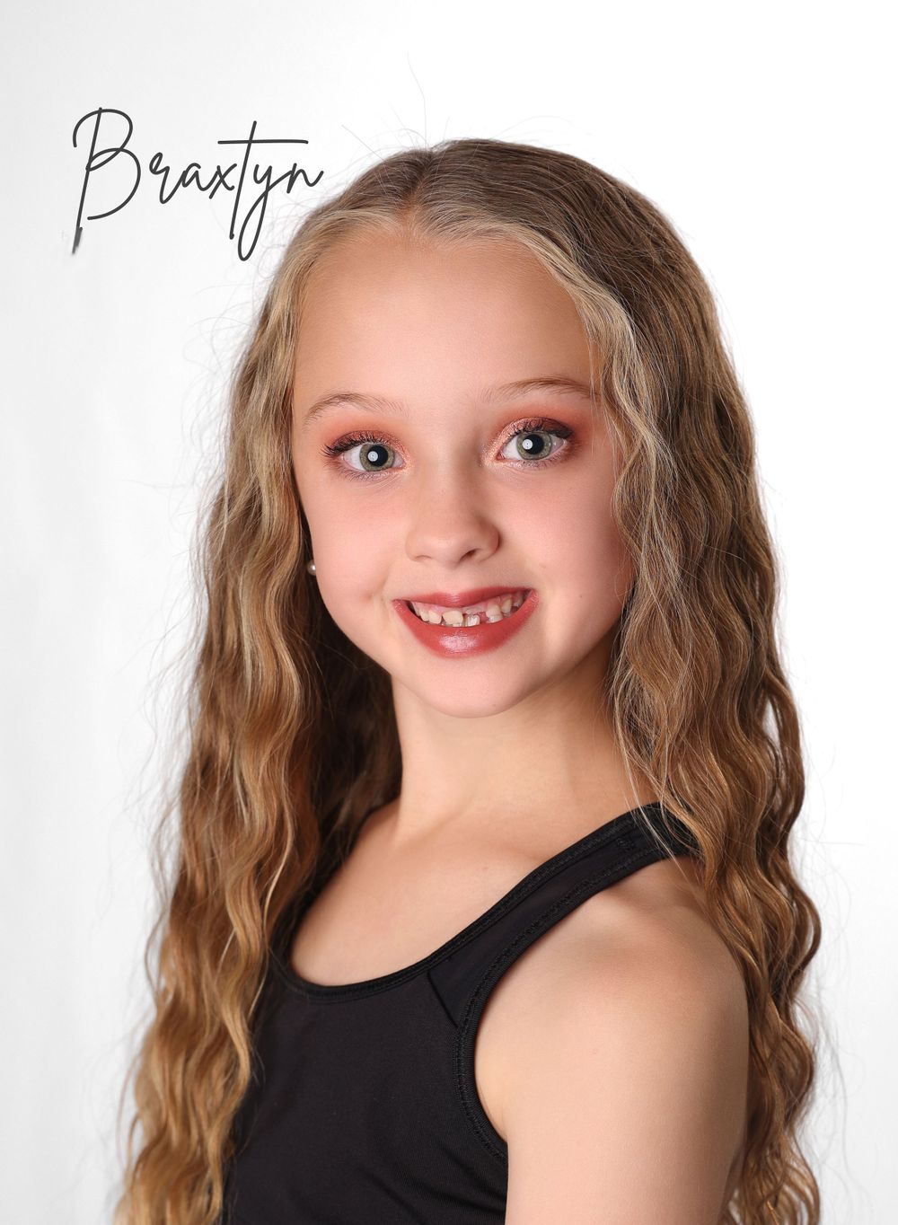 Studio portrait of young dancer in black leotard against white background.