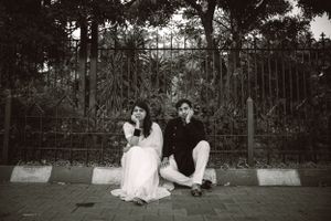 Black and white photos capturing intimate moments in a garden setting with iron fencing.