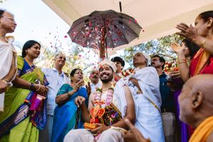Celebratory moment with confetti and umbrellas during an outdoor wedding ceremony.