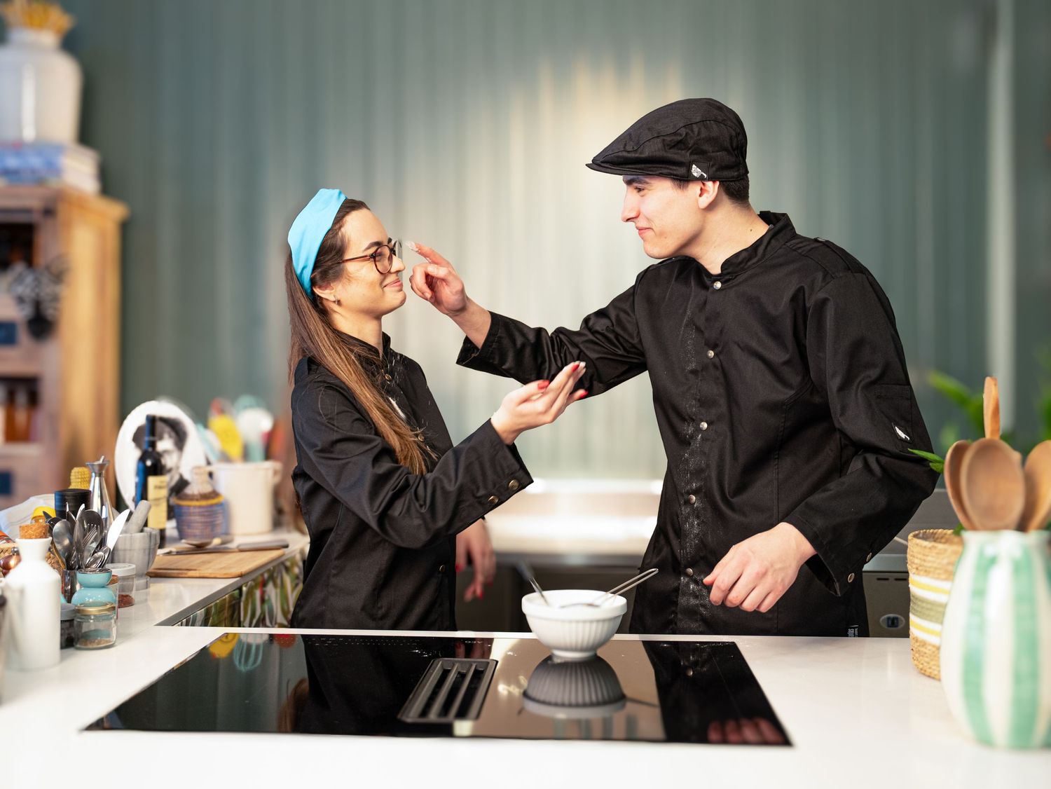 Staff members in black uniforms interacting at a modern cafe counter.