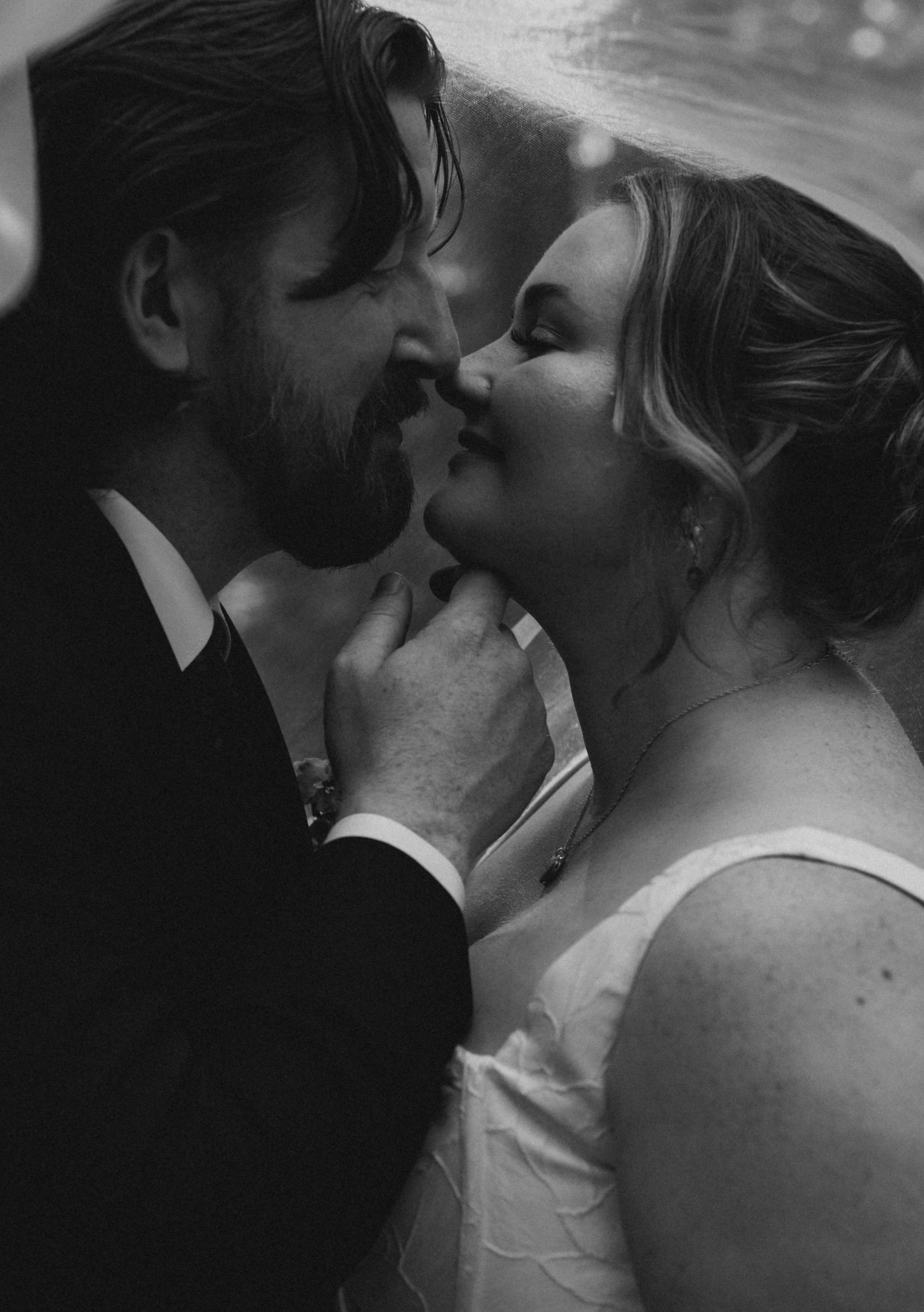 Black and white image showing intertwined hands in an intimate moment.