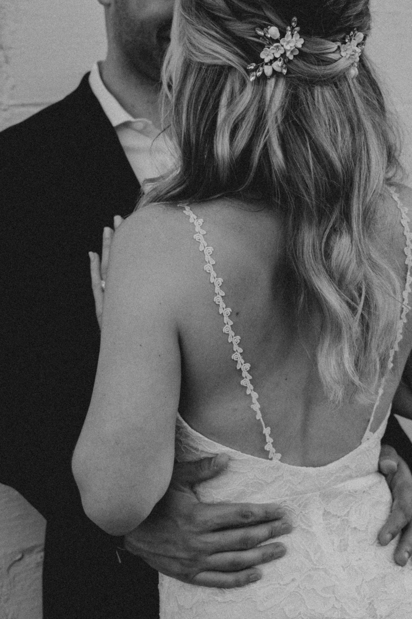Black and white image showing intertwined hands in an intimate moment.