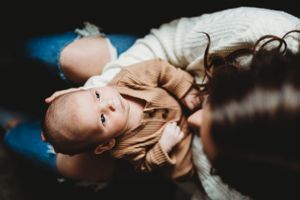 Close-up shot of a baby lying down and looking up at the camera.