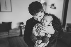 A tender moment between parent and infant in a cozy living room setting.