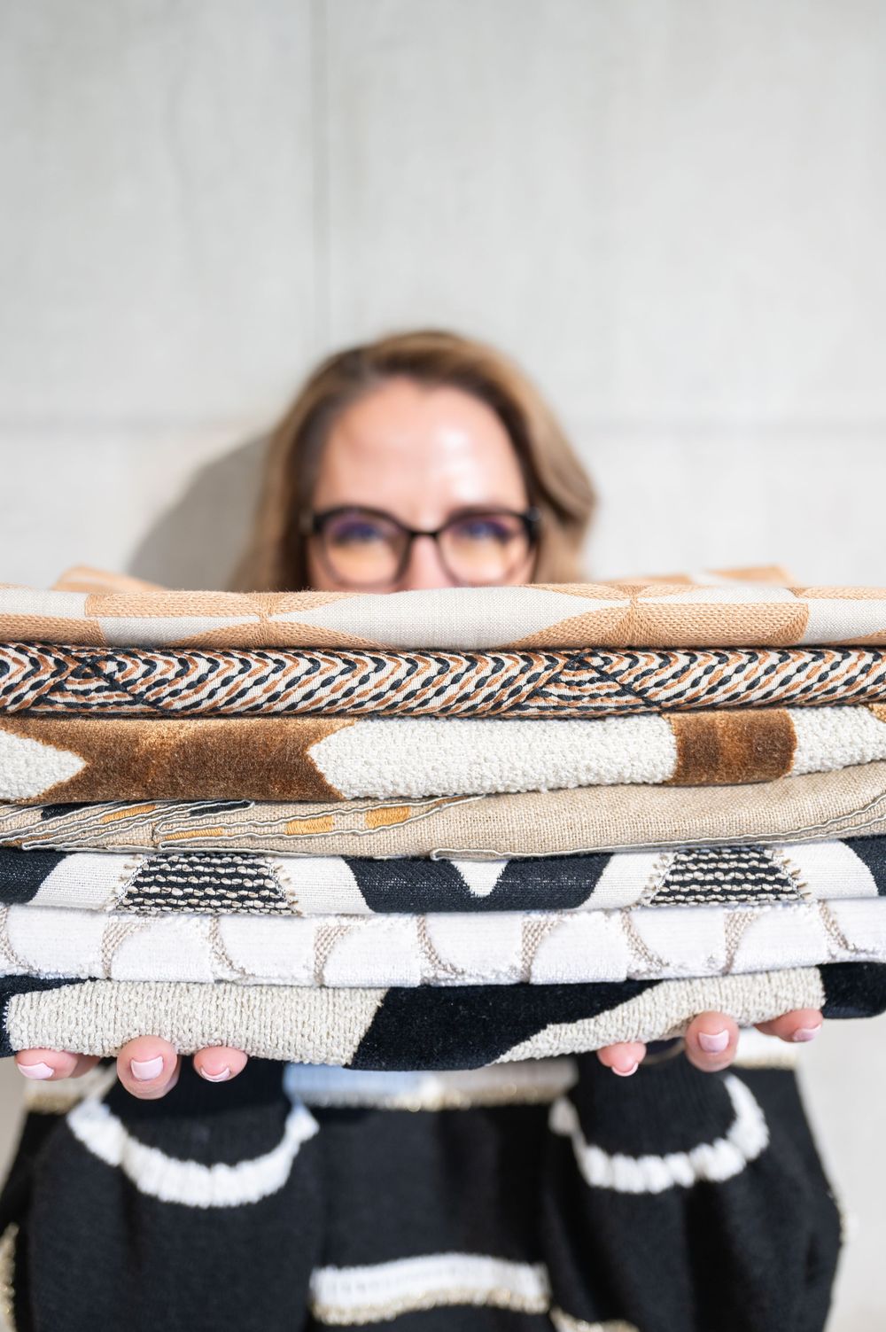 A stack of neatly folded black and white patterned sweaters or knit garments shown from the side.