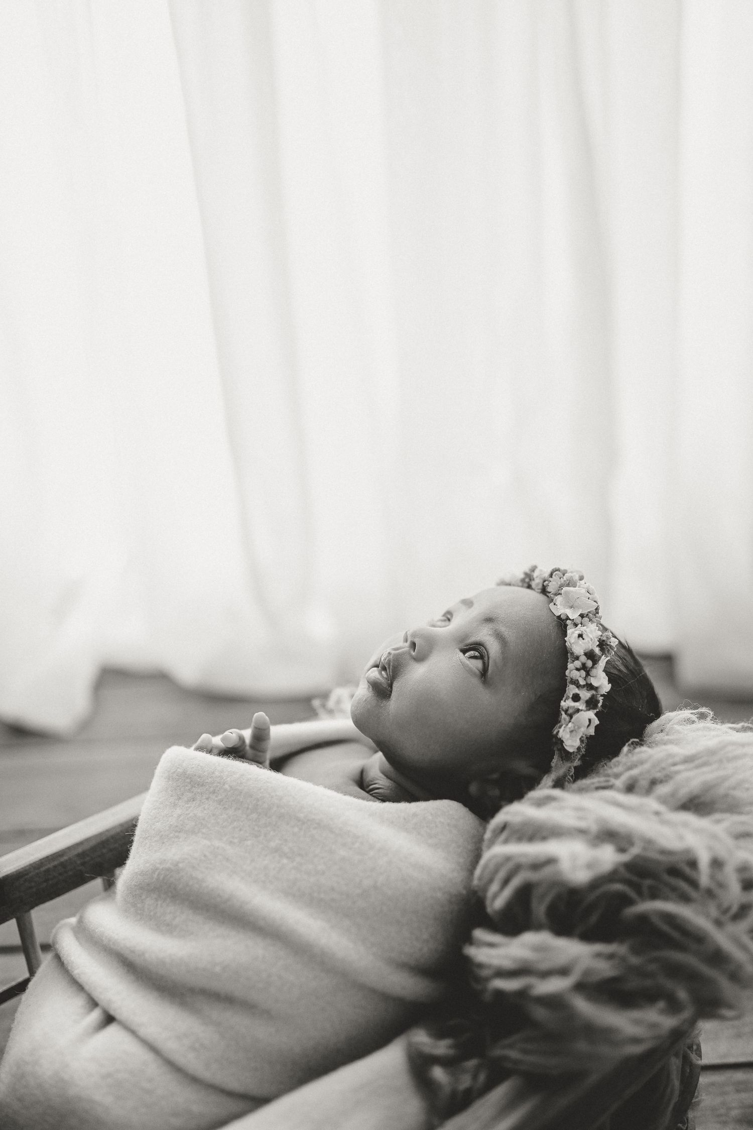 Newborn baby girl looks up during newborn photography session in Clarksville, Tennessee.