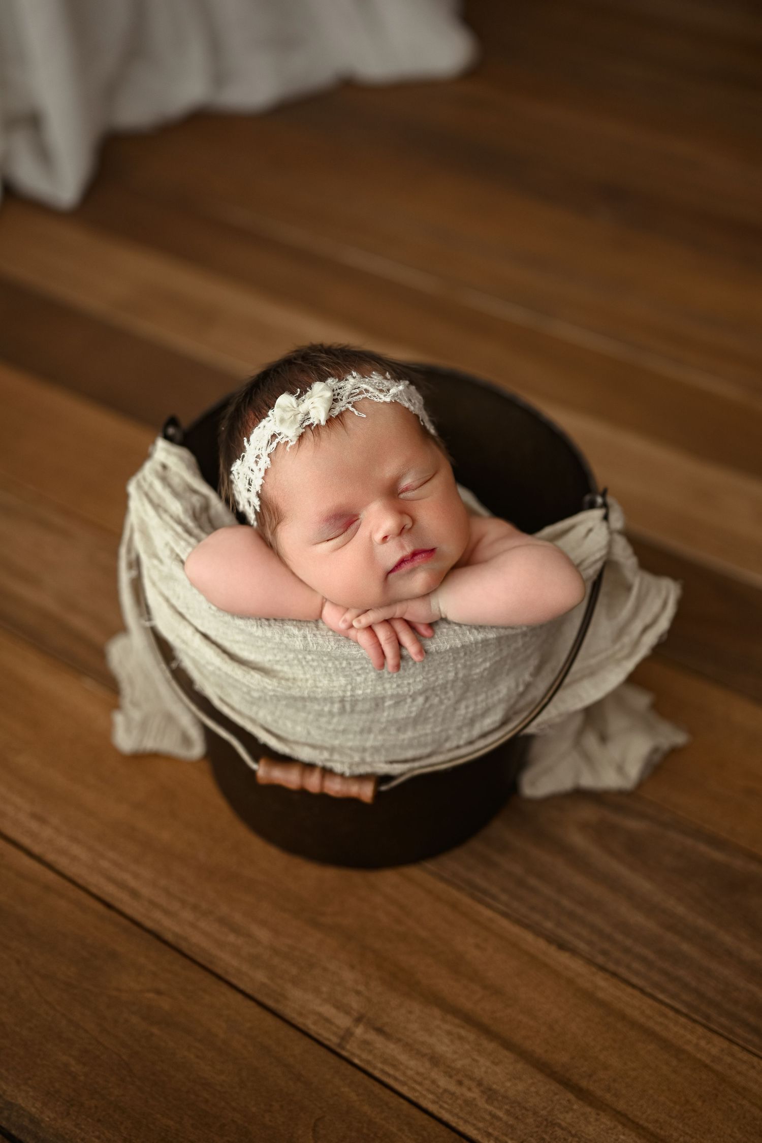 Newborn baby girl sleeps in bucket during newborn photography session in Clarksville, Tennessee by Disney Magic Photography.
