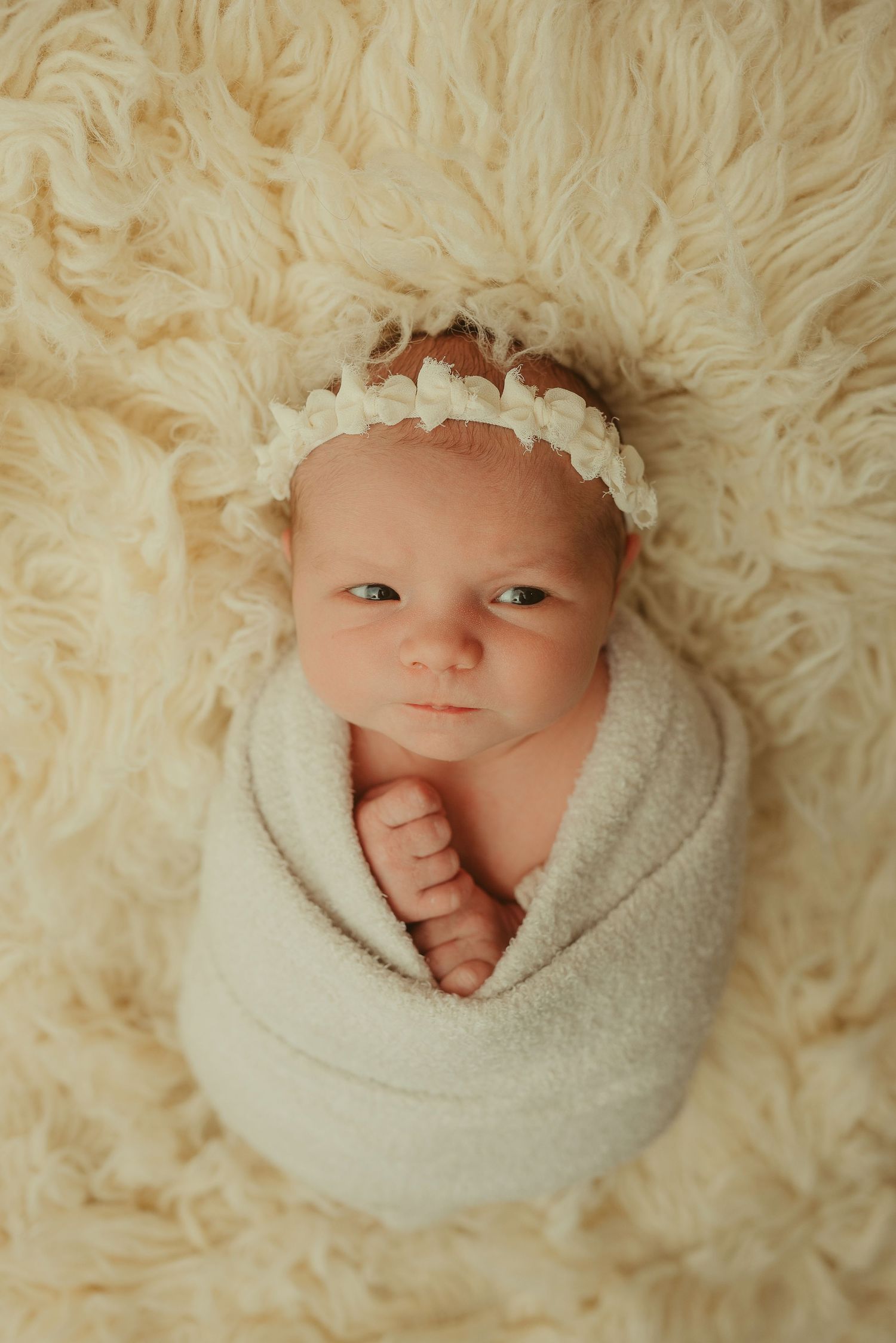 Baby girl gives suspicious look during studio newborn photography session at Disney Magic Photography studio in Clarksville, Tennessee