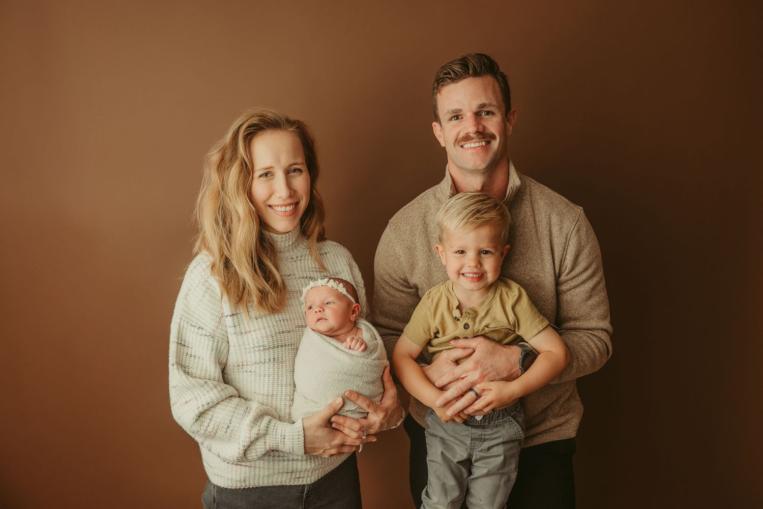 Beautiful new Fort Campbell military family poses with newborn baby girl during studio newborn photography session in Clarksville, TN